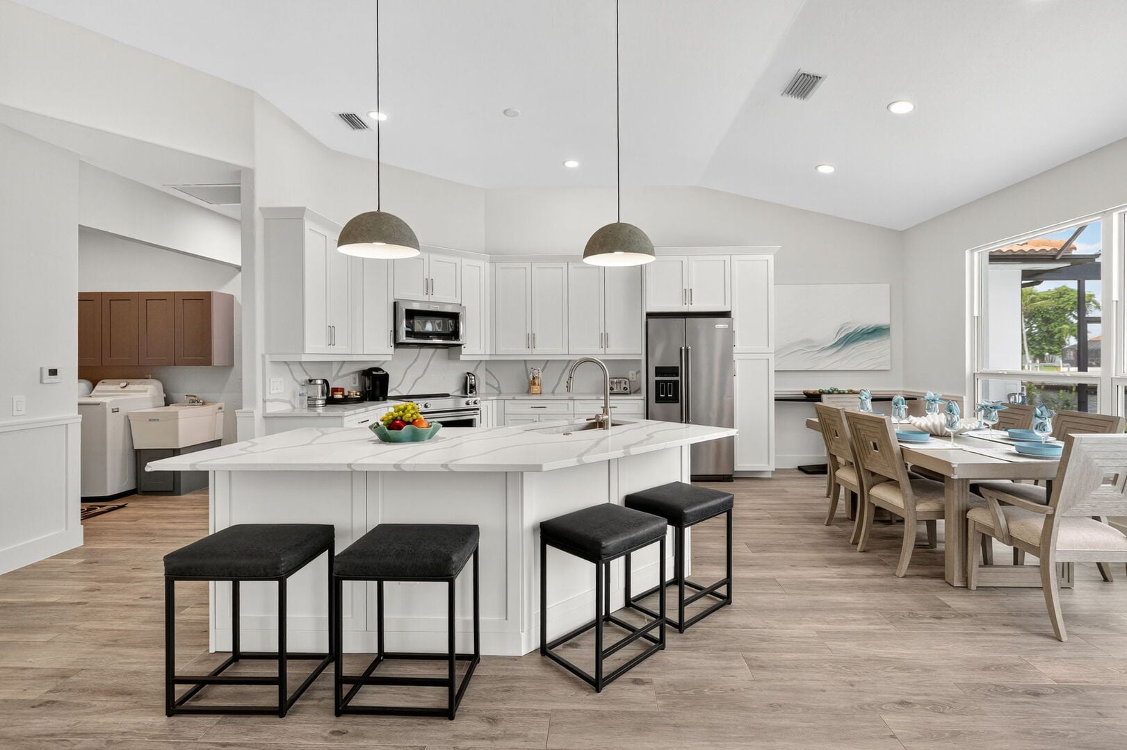 Große Lanai mit Esstisch, Sonnenliegen, Grill sowie Pool- und Kanalblick.