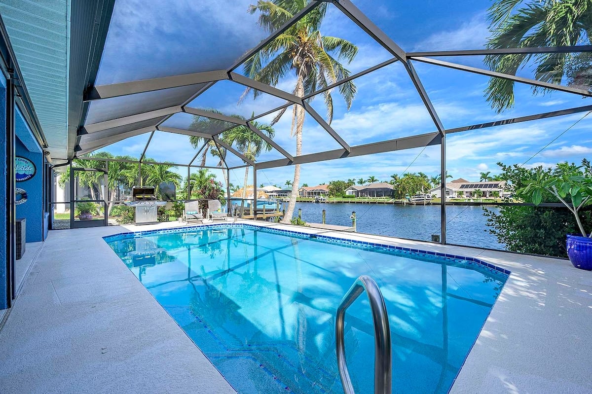 Privater Pool mit Sonnenliegen und Blick auf den Kanal.