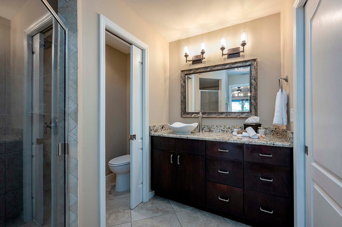 Überdachte Lanai mit Esstisch und Blick auf Pool und Kanal.