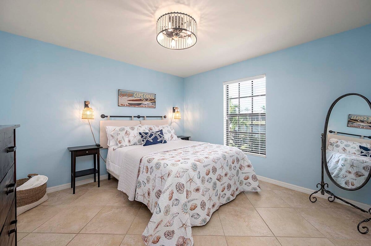 Überdachte Lanai mit Outdoor-Esstisch und Blick auf den Kanal.