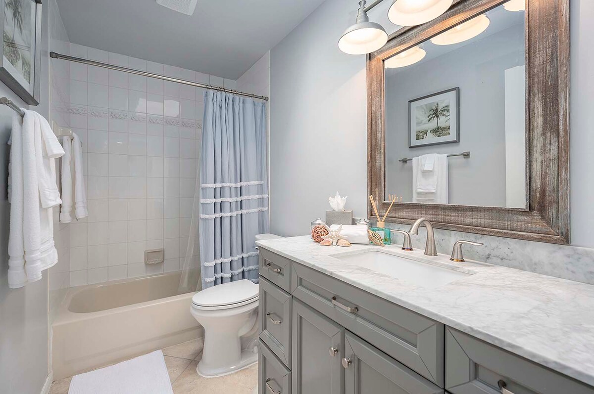 Überdachte Lanai mit Esstisch und Blick auf den Poolbereich.