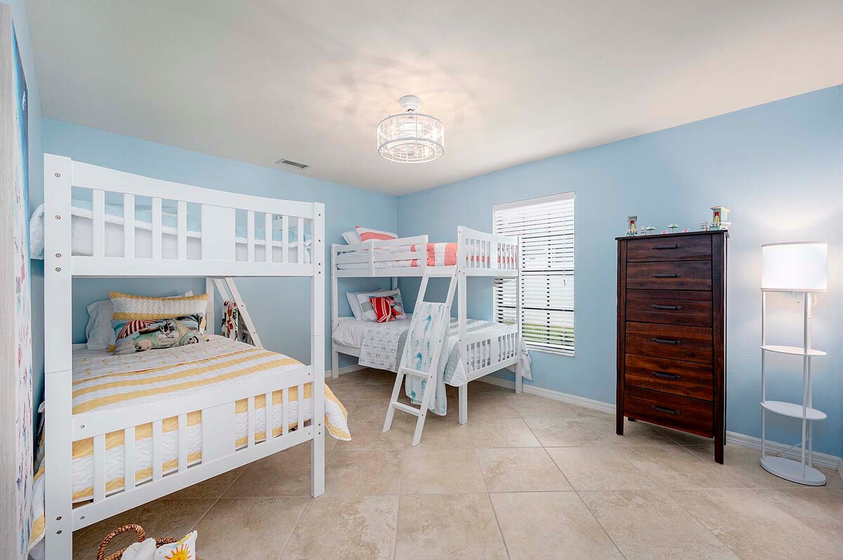 Überdachte Lanai mit Esstisch und Blick auf den Poolbereich.