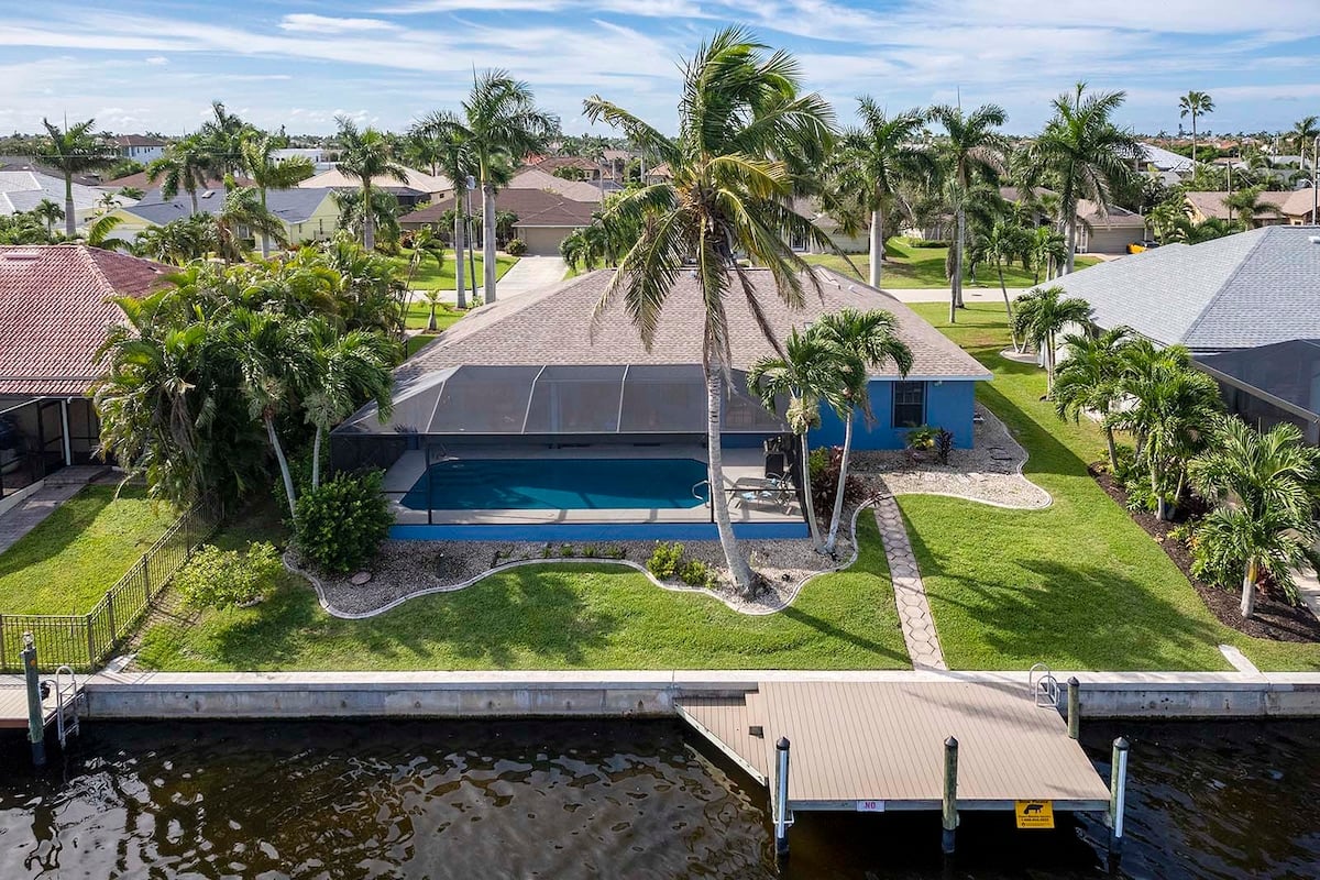 Überdachte Lanai mit Esstisch und Blick auf den Kanal.