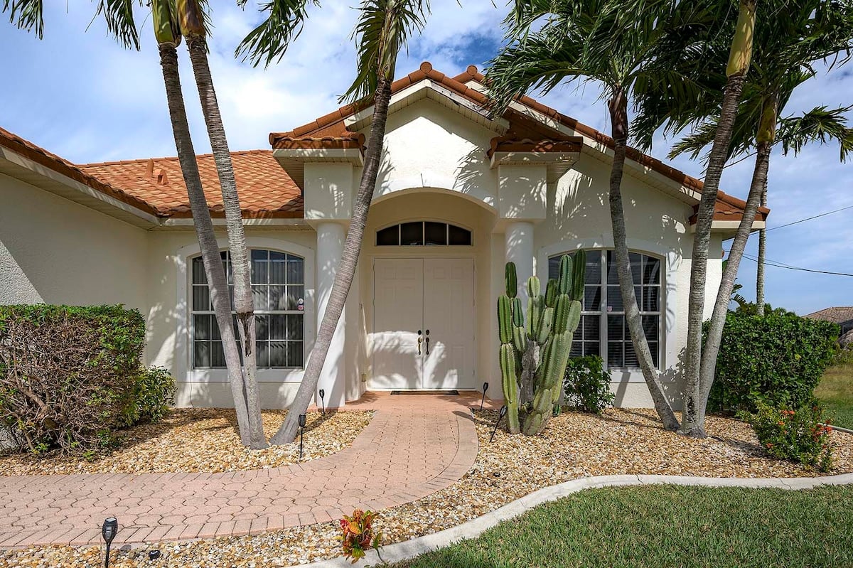 Außenbereich mit Pool, Whirlpool und Blick auf den Kanal mit Bootsdock.