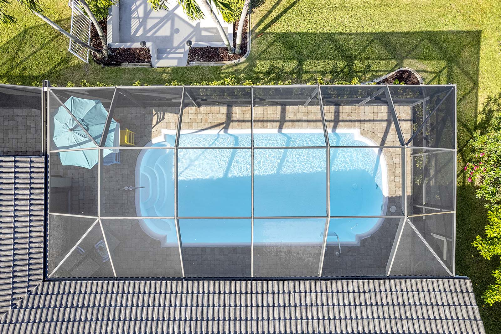 Westlich ausgerichtete Terrasse am Kanal mit privatem Dock und Bootslift bei Sonnenuntergang.