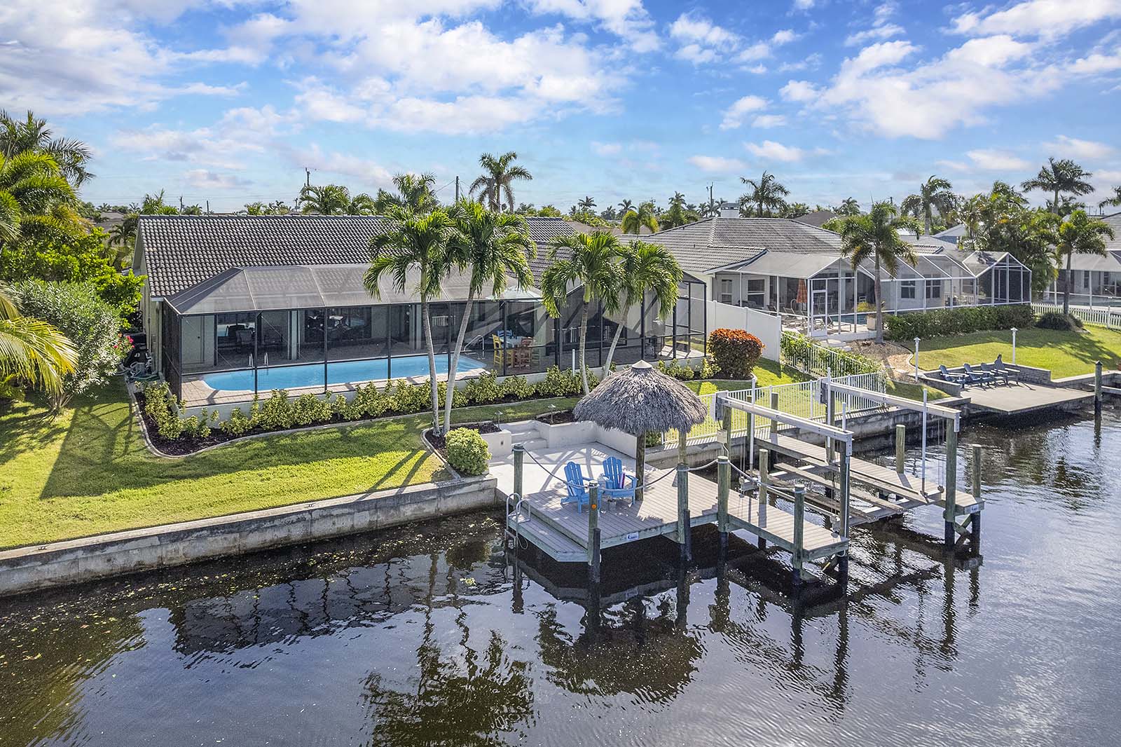 Westlich ausgerichtete Terrasse am Kanal mit privatem Dock und Bootslift bei Sonnenuntergang.