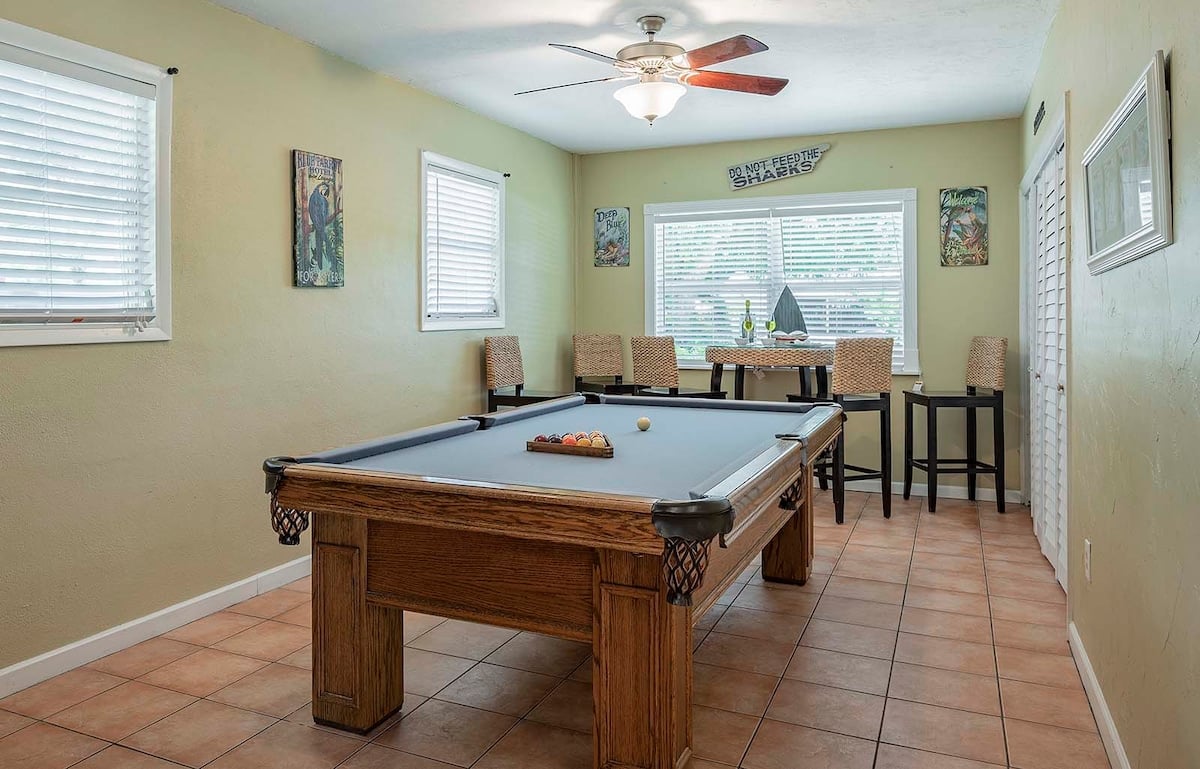 Beheizter Pool mit Sonnenliegen und TV im Außenbereich.