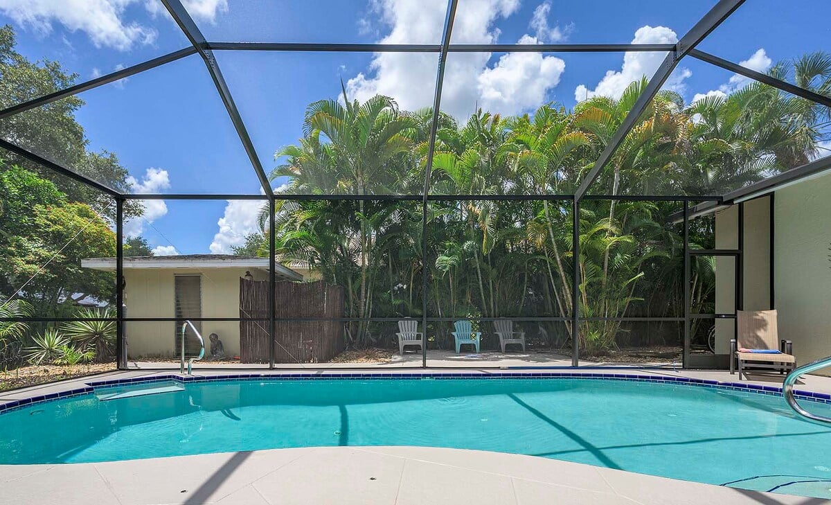 Beheizter Pool mit Sonnenliegen und TV im Poolbereich.