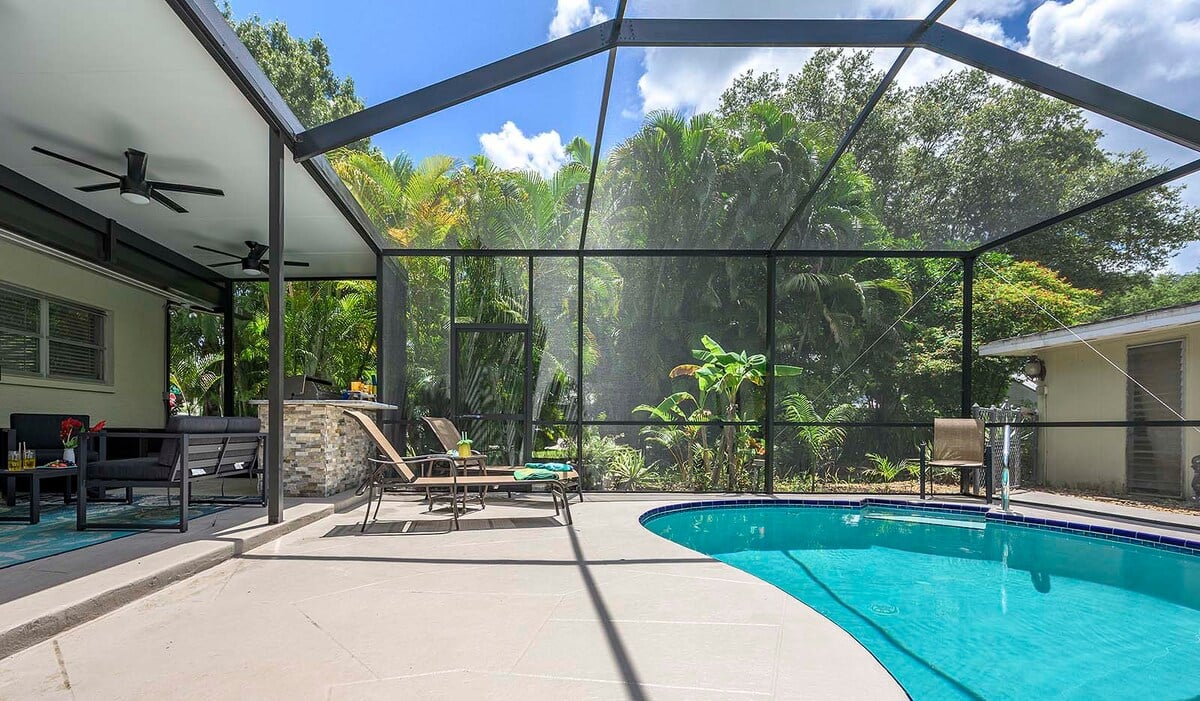 Beheizter Pool mit Sonnenliegen und TV im Poolbereich.