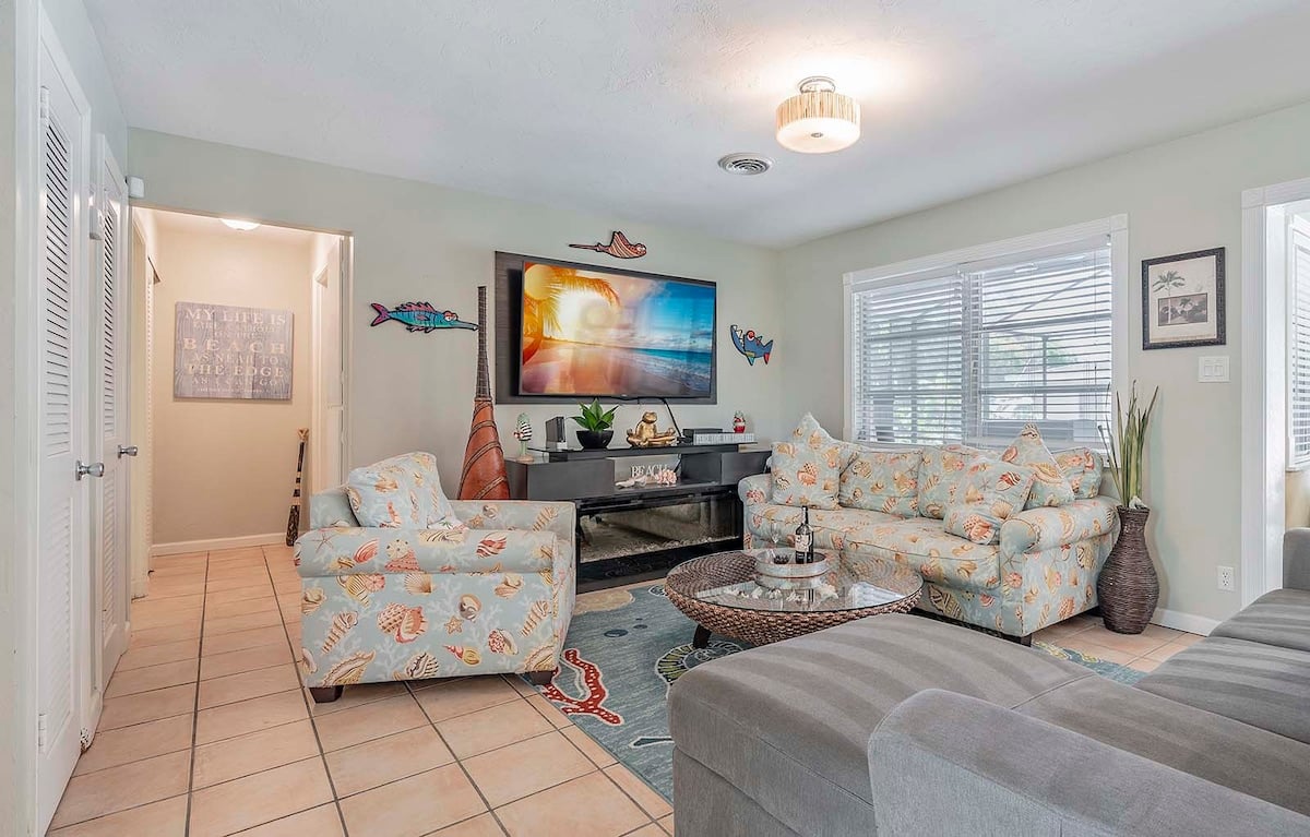 Beheizter Pool mit Sonnenliegen und TV im Außenbereich.