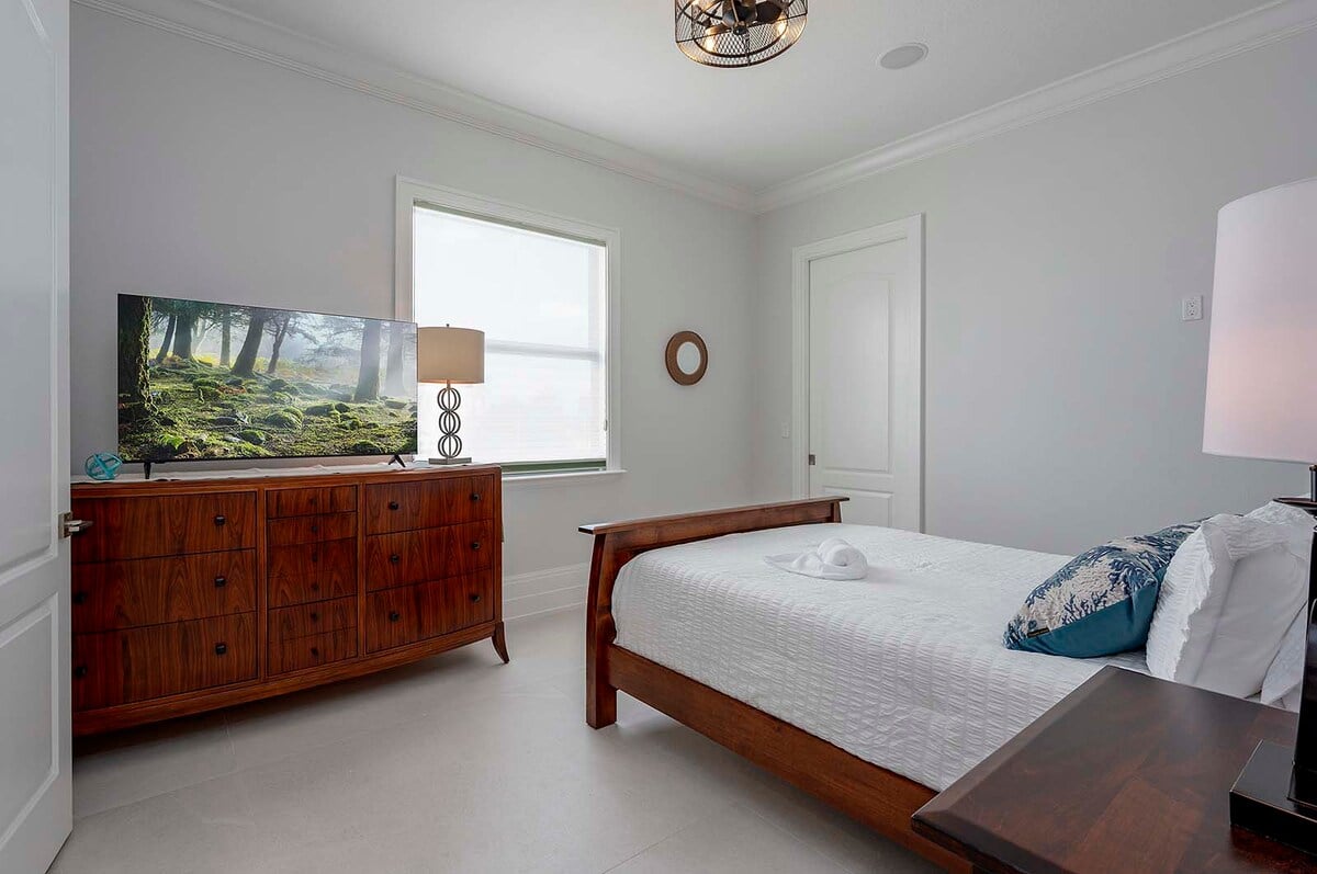 Schlafzimmer mit Queensize-Bett, TV, begehbarem Kleiderschrank und eigenem Bad