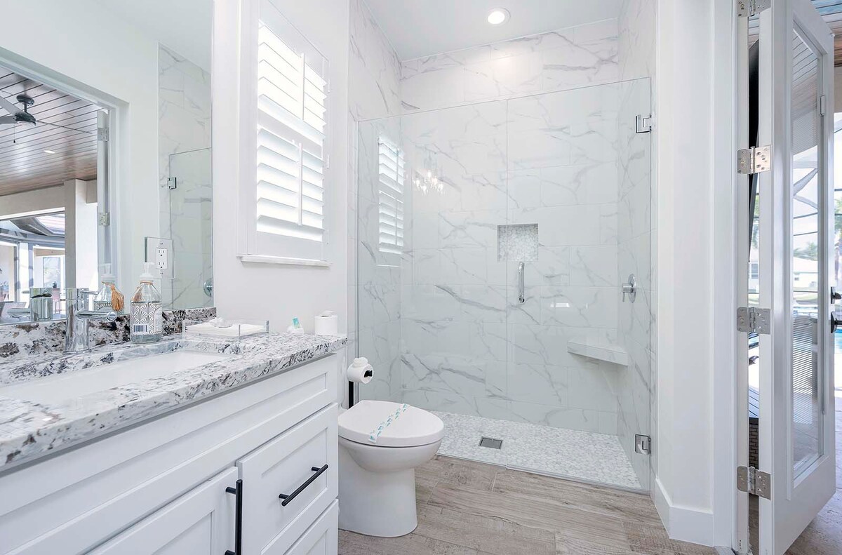 Großer Wohnbereich mit Blick auf Pool und Kanal.