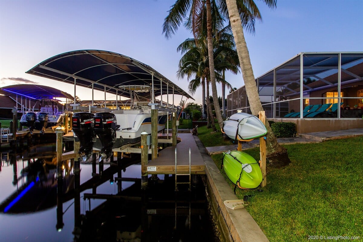 Terrasse am Kanal mit Bootsdock und Wasserblick bei Sonnenuntergang.