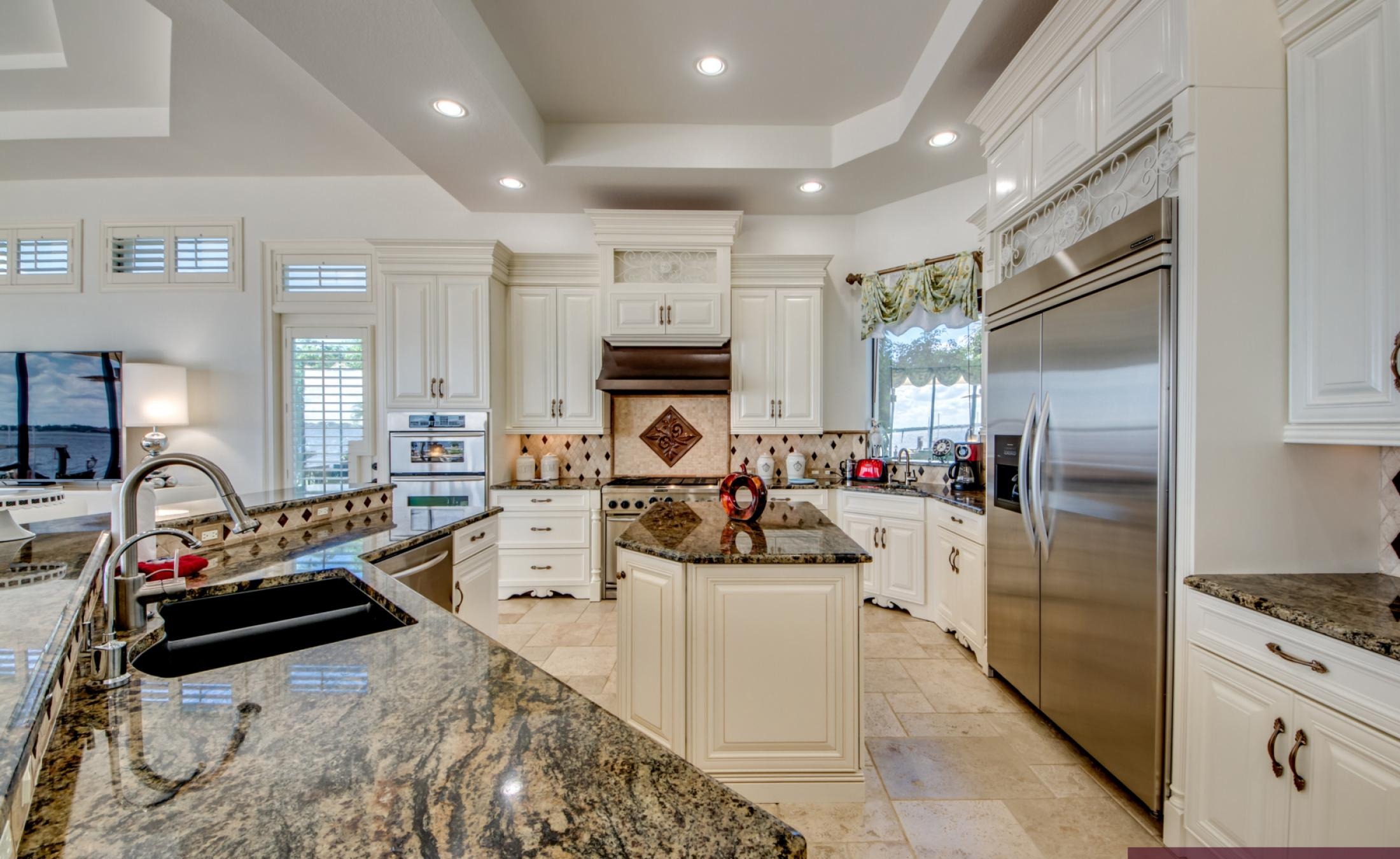 Infinity-Pool und Spa auf der sonnigen Lanai mit Blick auf den Fluss und Bootsdock.