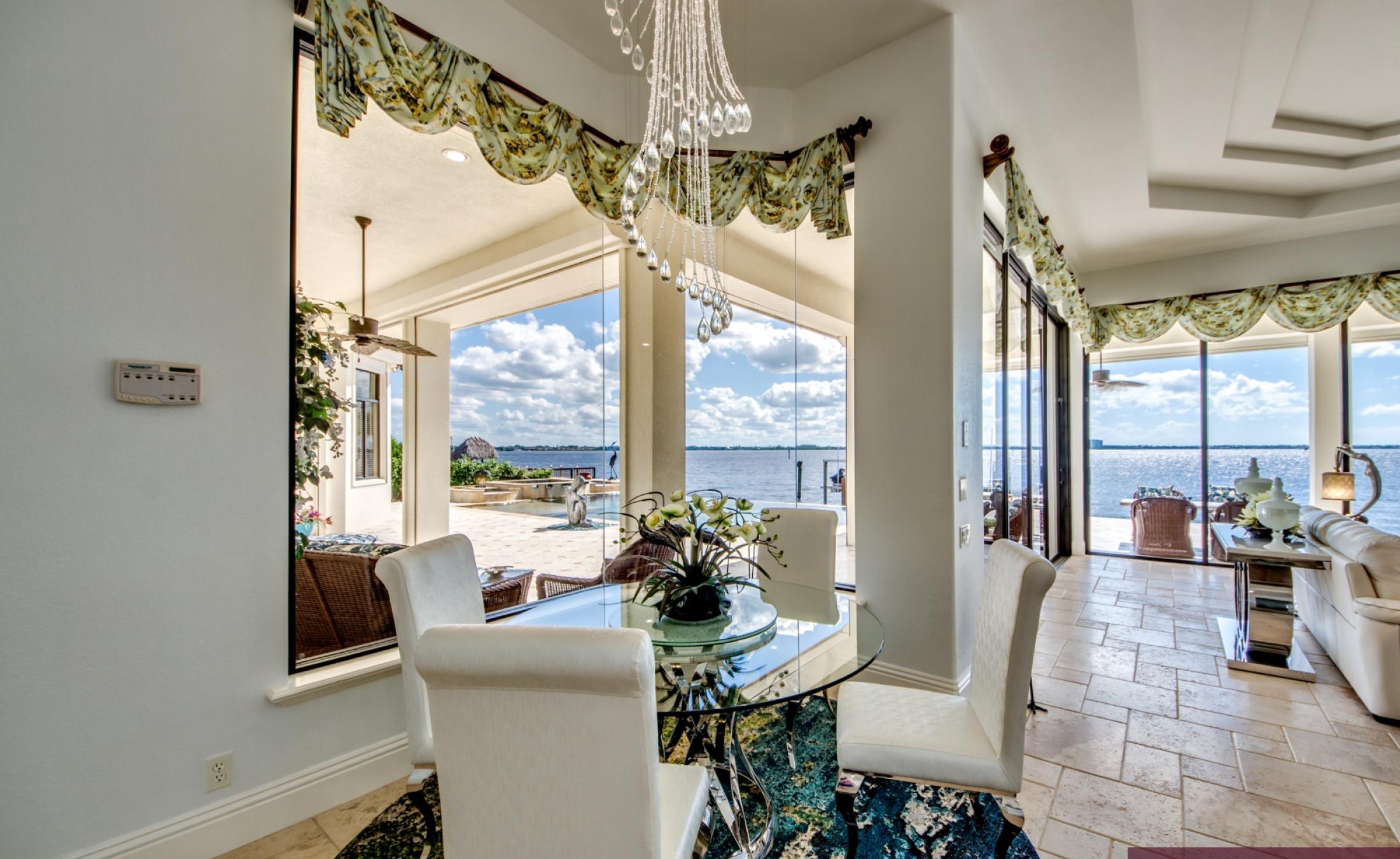 Sonnige Lanai mit Infinity-Pool und Spa am Fluss, mit Bootsdock und Wasserblick.