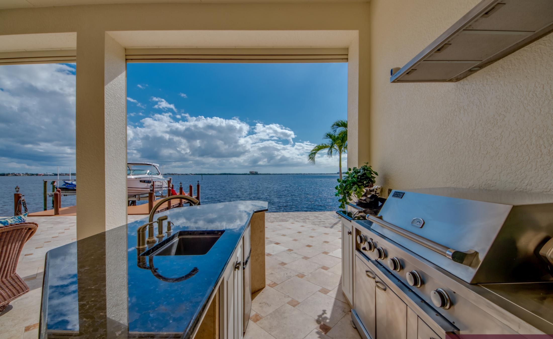 Infinity-Pool mit Spa auf sonniger Lanai mit Flussblick und Bootsdock.