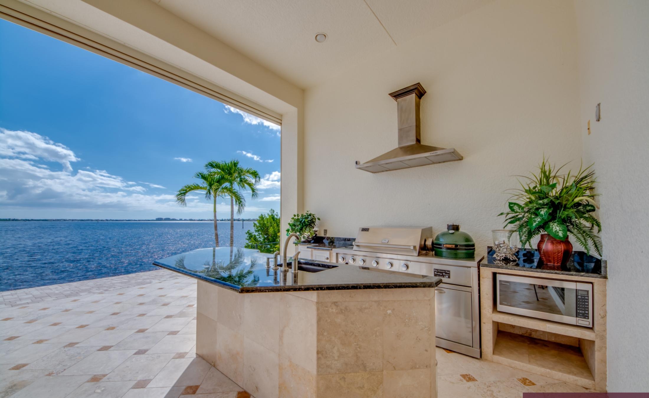 Sonnige Lanai mit Infinity-Pool, Spa und Blick auf den Fluss mit Bootsdock.