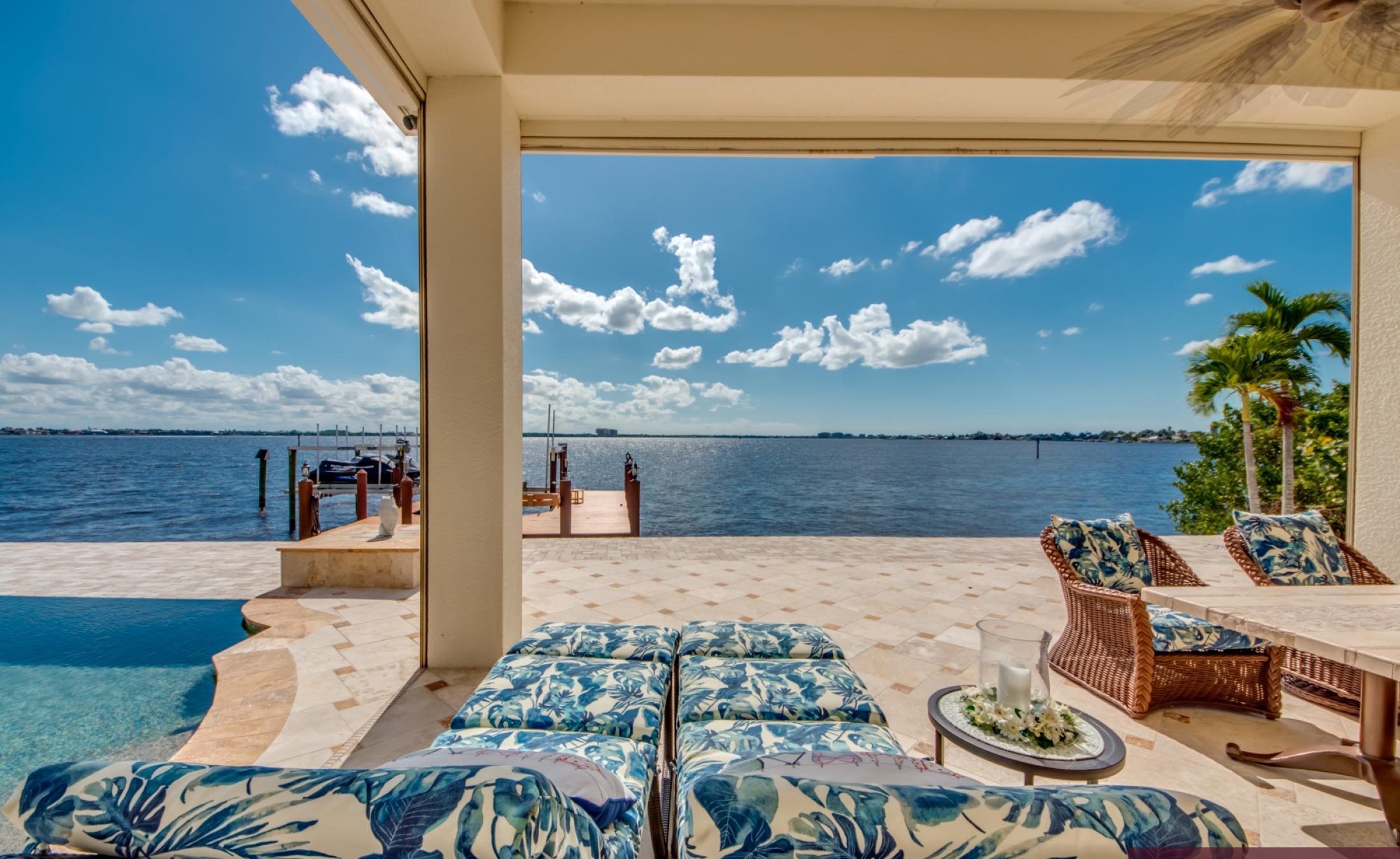 Sonnige Poolterrasse mit Infinity-Pool, Spa und Blick auf den Fluss.