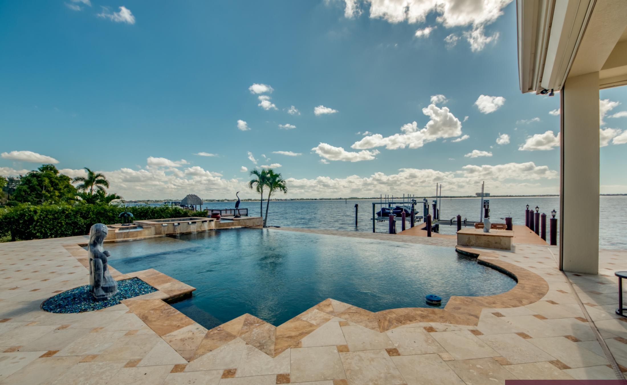 Infinity-Pool und Spa auf der sonnigen Lanai mit Blick auf den Fluss und Bootsdock.