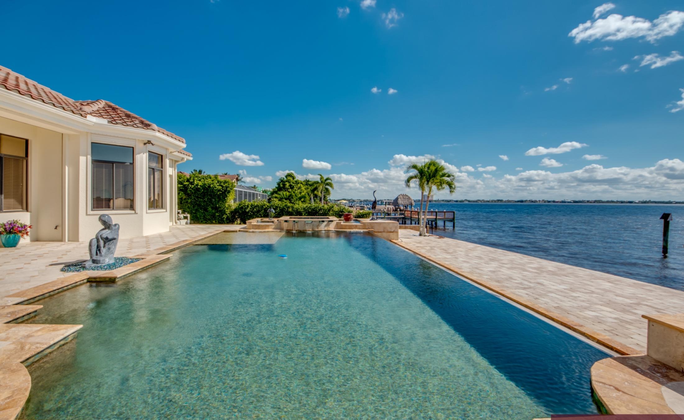 Sonnige Lanai mit Infinity-Pool, Spa und Blick auf den Fluss.