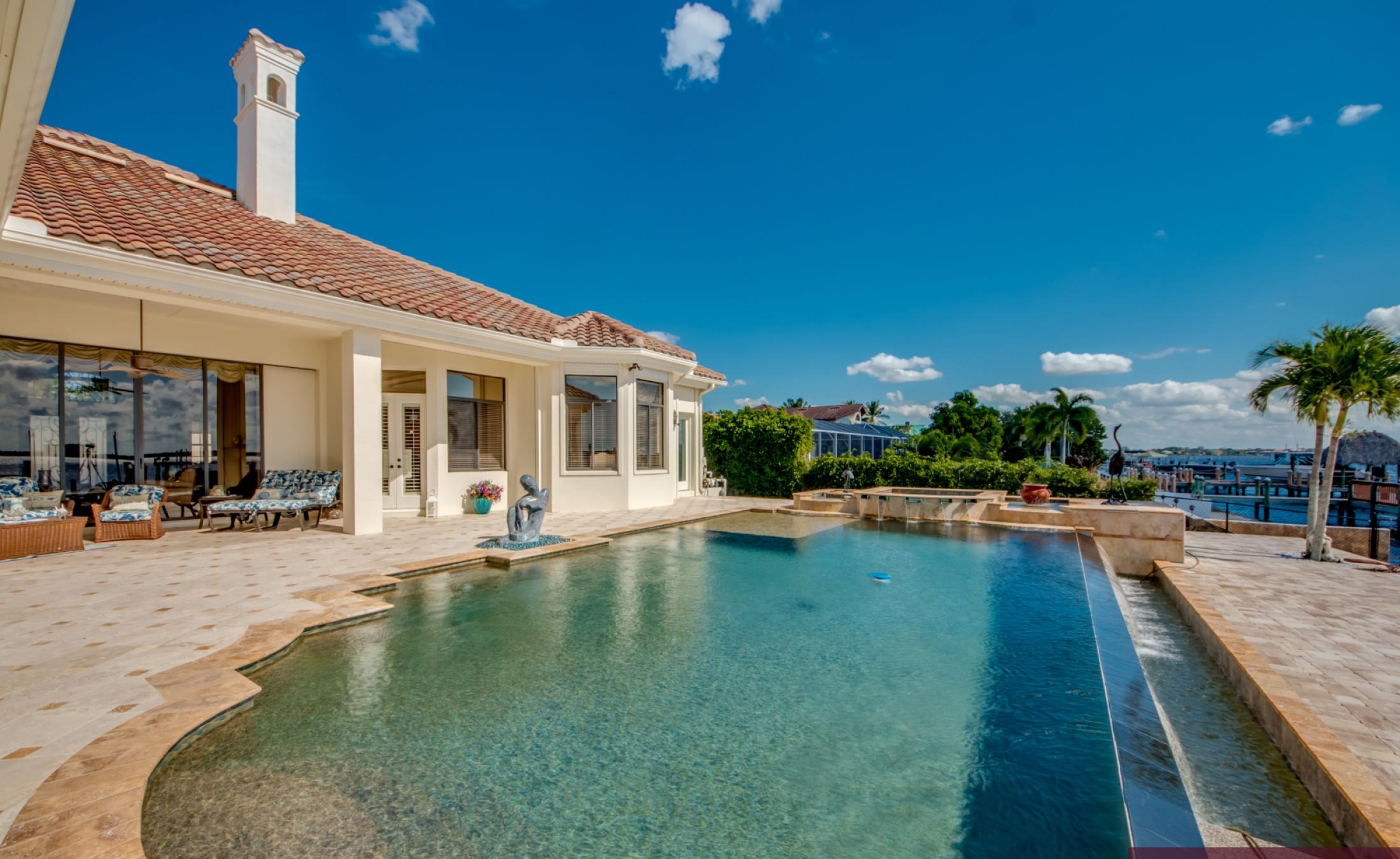 Infinity-Pool mit Spa und Blick auf den Fluss, daneben Bootsdock.