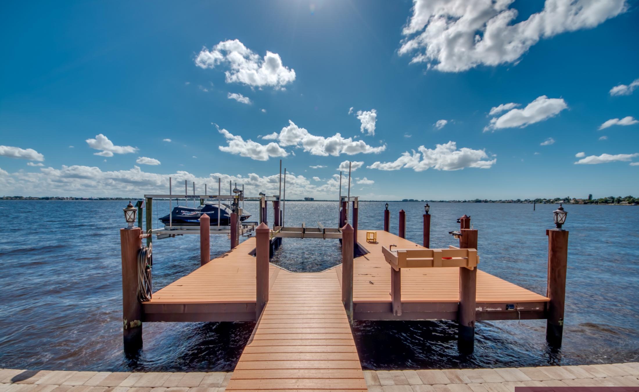 Infinity-Pool mit Spa auf der sonnigen Lanai mit Blick aufs Wasser.