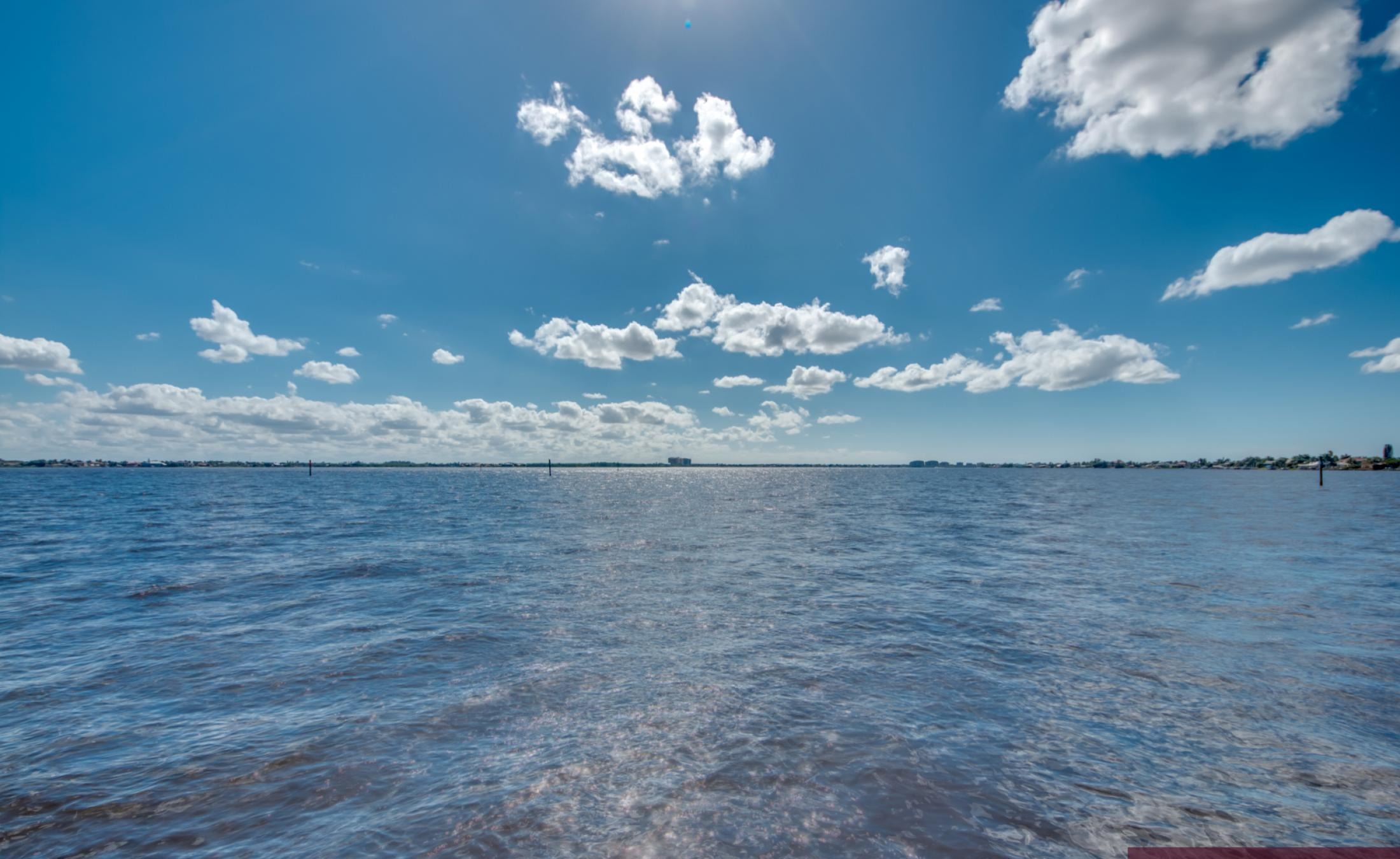 Infinity-Pool und Spa auf der sonnigen Lanai mit Blick auf den Fluss.