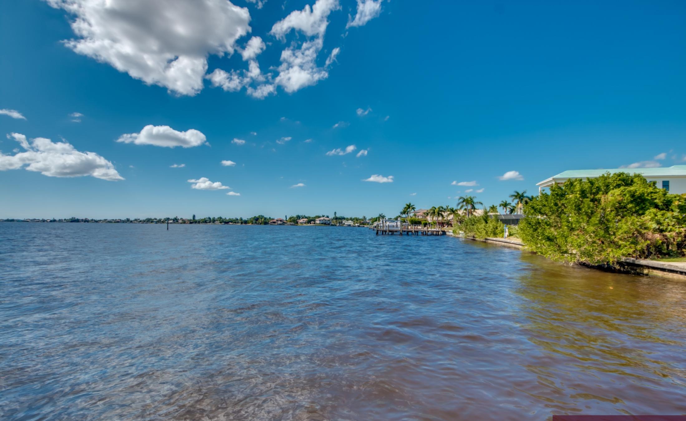 Infinity-Pool mit Spa auf der sonnigen Lanai mit Blick auf den Fluss und Bootsdock.