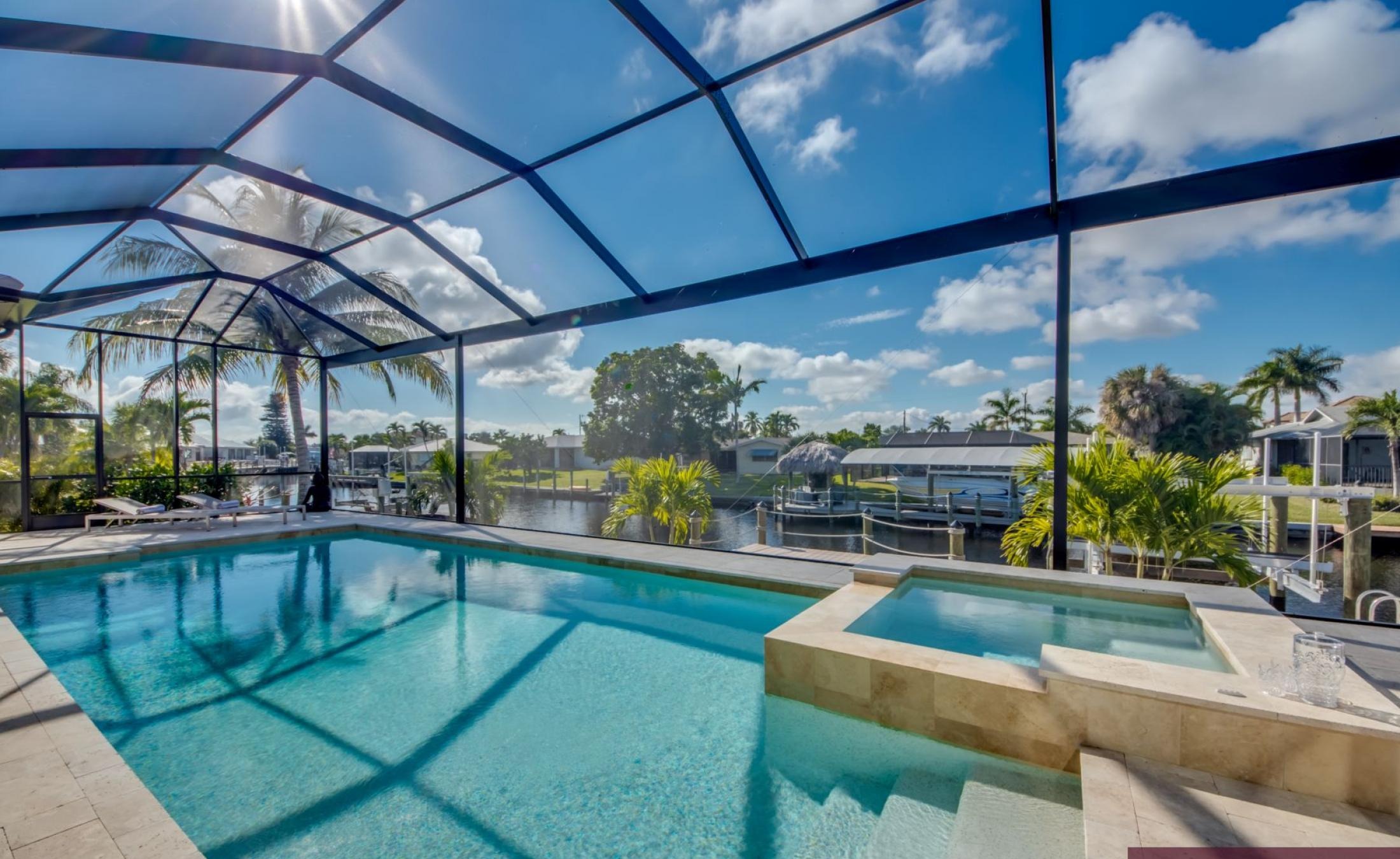 Elektrisch beheizter Pool und Jacuzzi im Außenbereich mit Blick aufs Wasser.