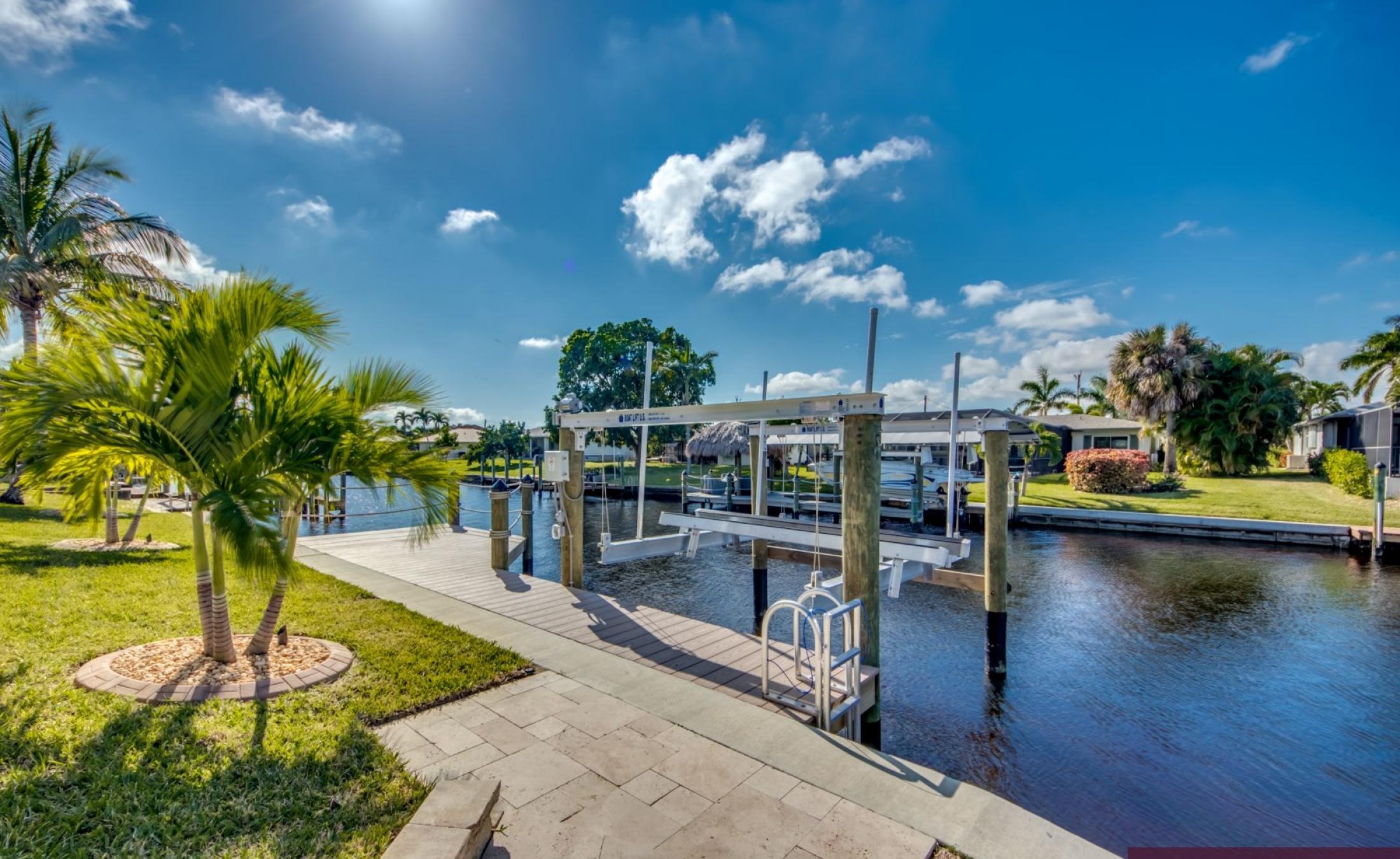 Außenbereich am Wasser mit privatem Bootsdock und beheiztem Pool mit Jacuzzi.