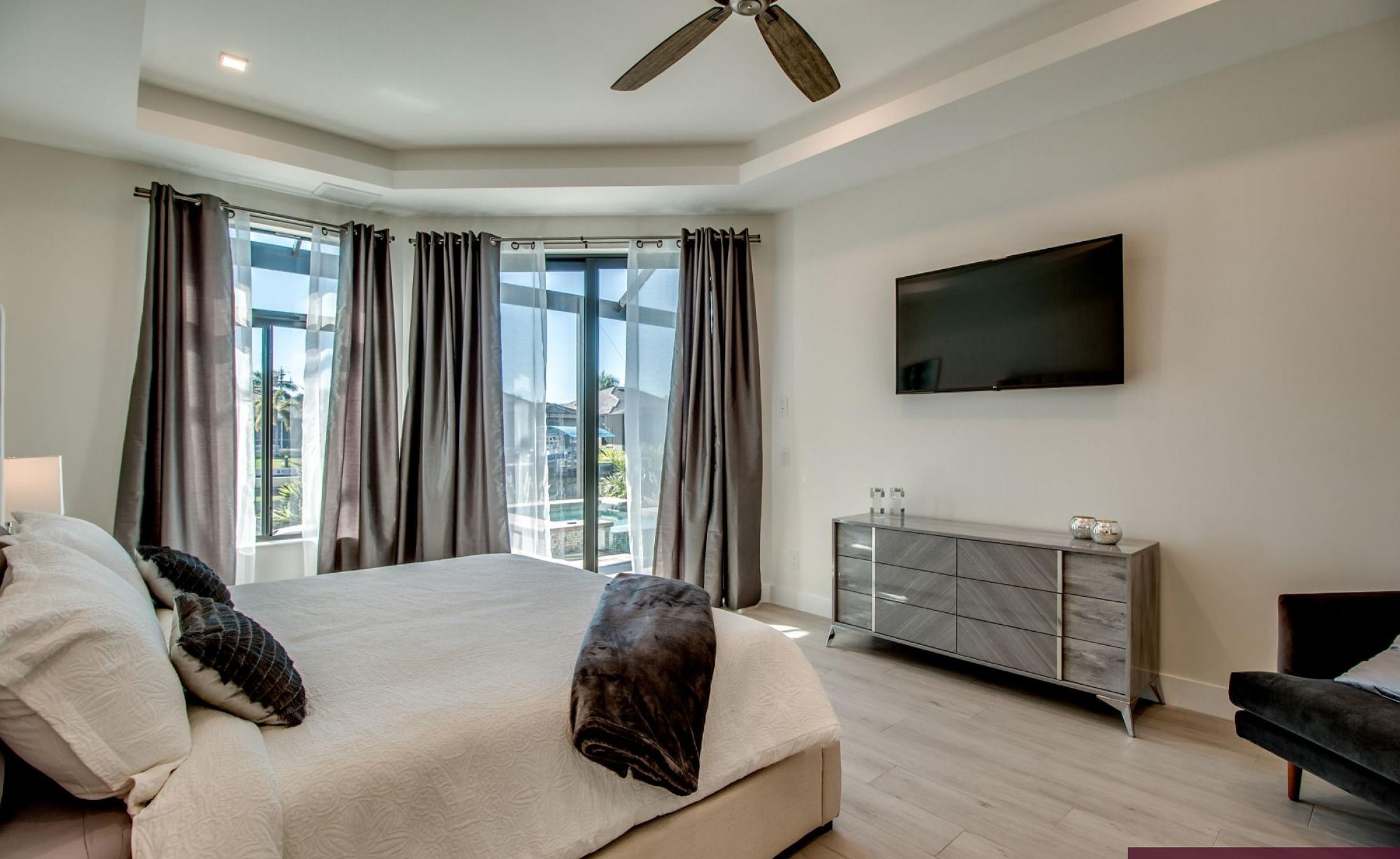 Außenbereich mit Pool, Spa und Grillplatz am Wasser.