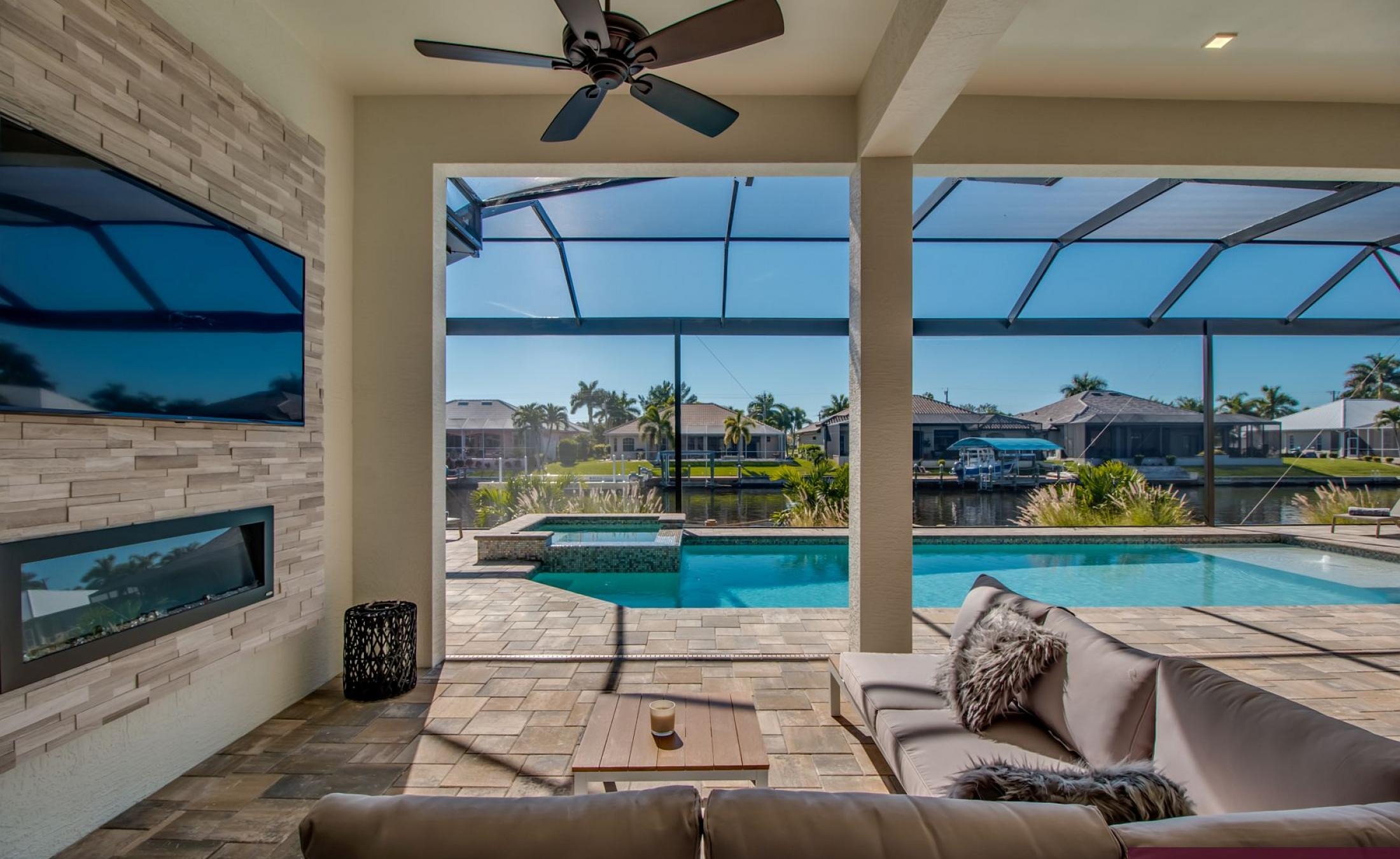 Außenbereich mit beheiztem Pool, Spa und Grillplatz am Wasser.