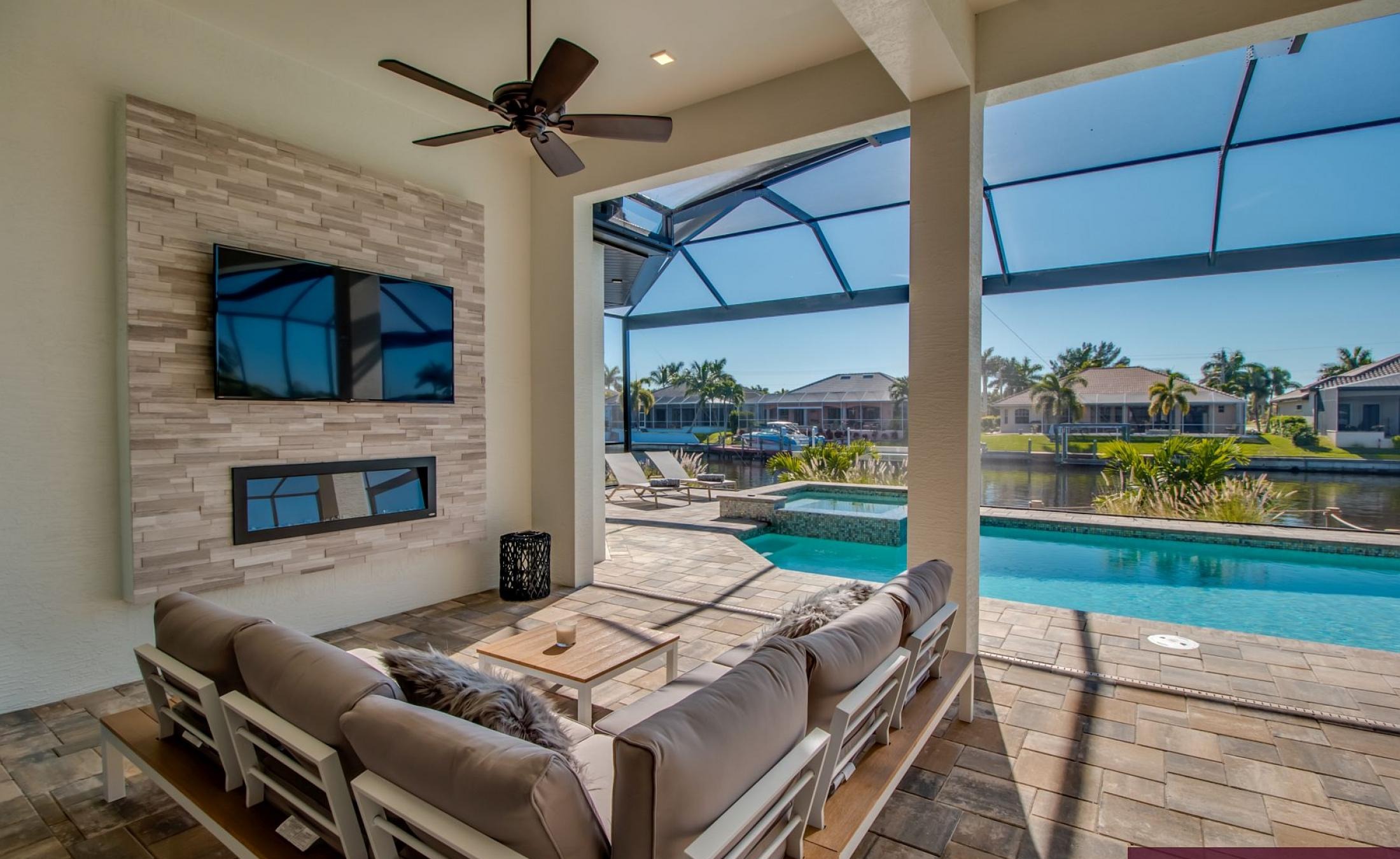 Überdachte Terrasse mit Pool, Spa und Grillbereich am Wasser.