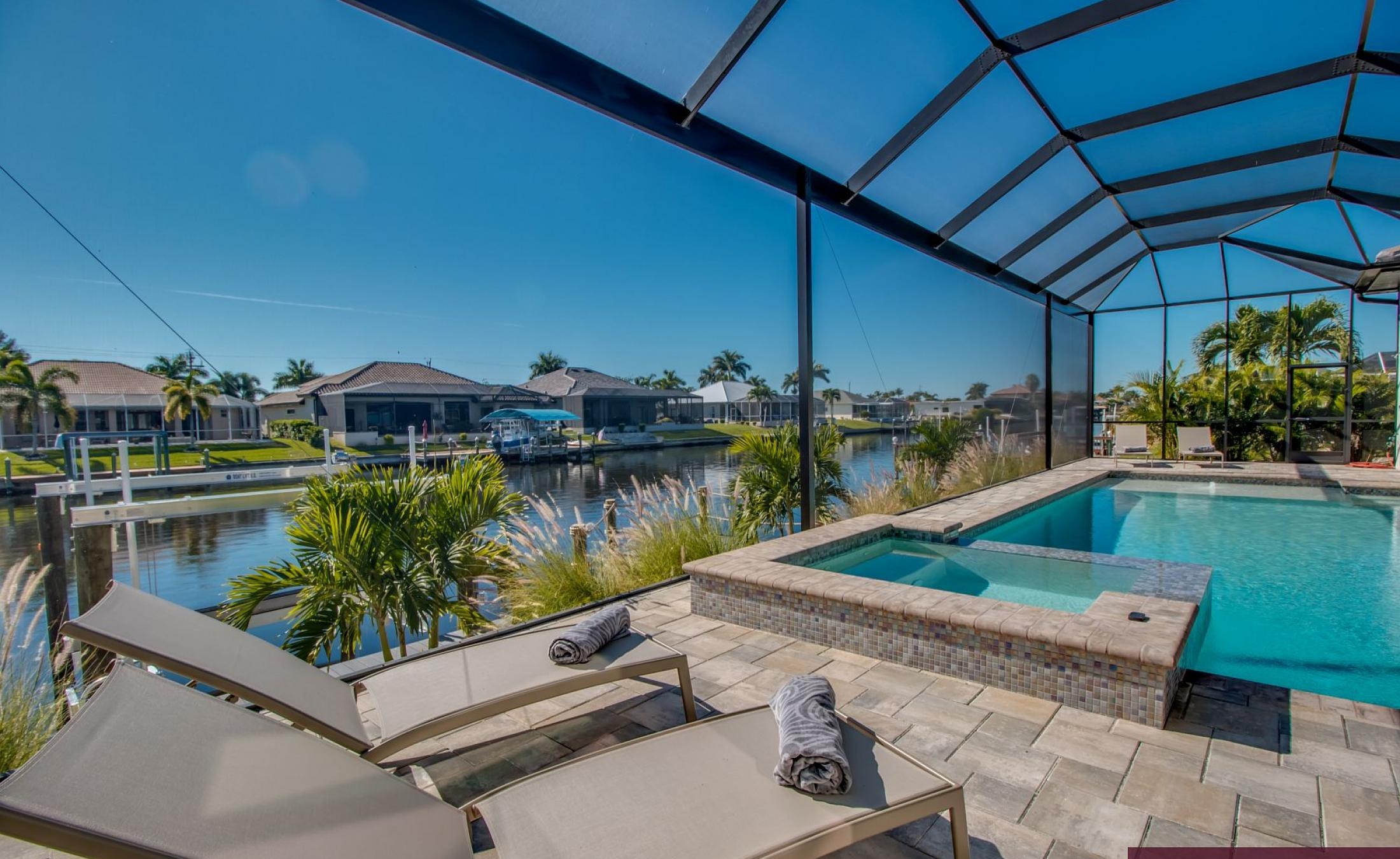 Sonniger Poolbereich mit Spa und Blick auf den Kanal.