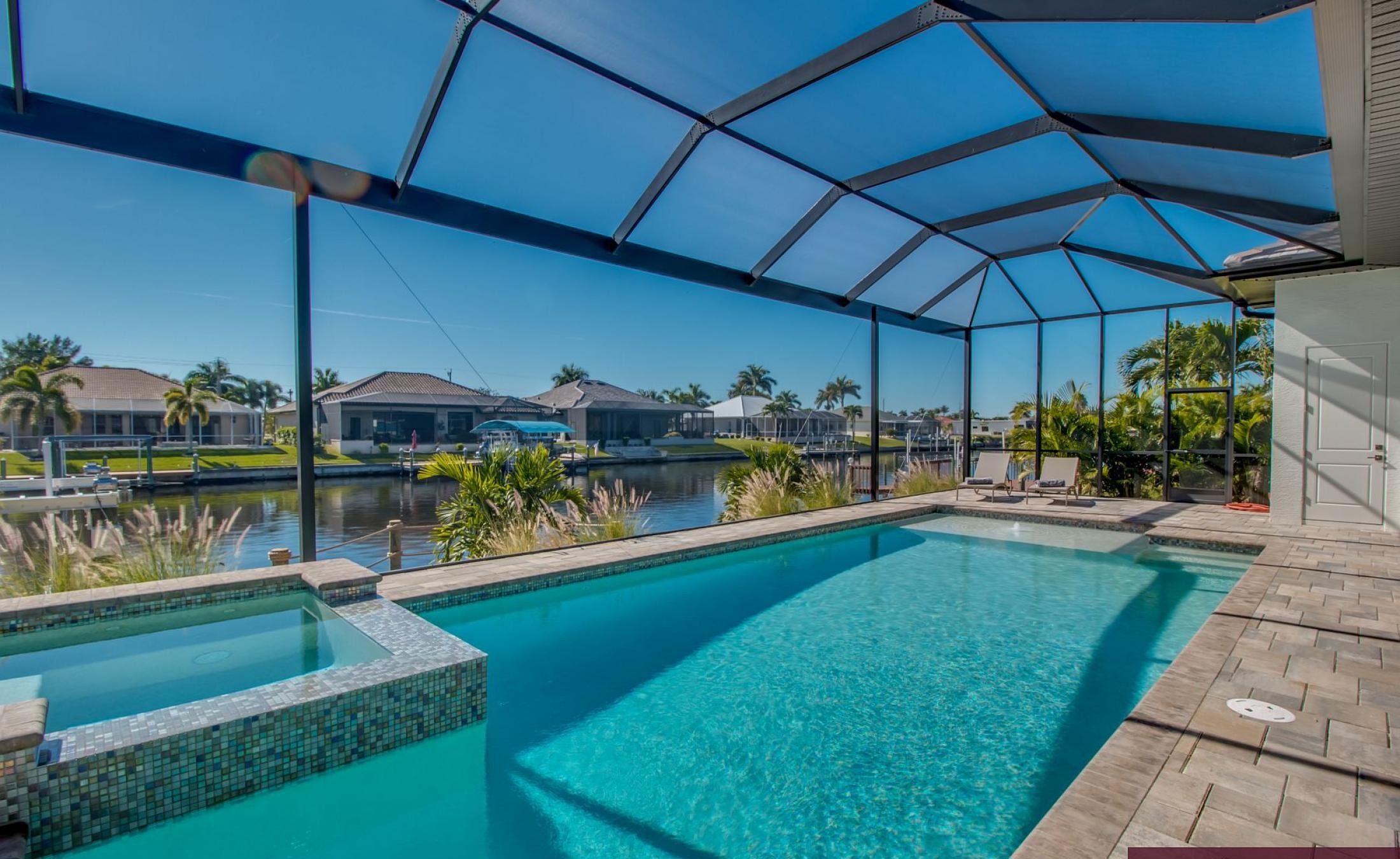 Überdachter Poolbereich mit beheiztem Pool, integriertem Spa und Blick auf den Kanal.