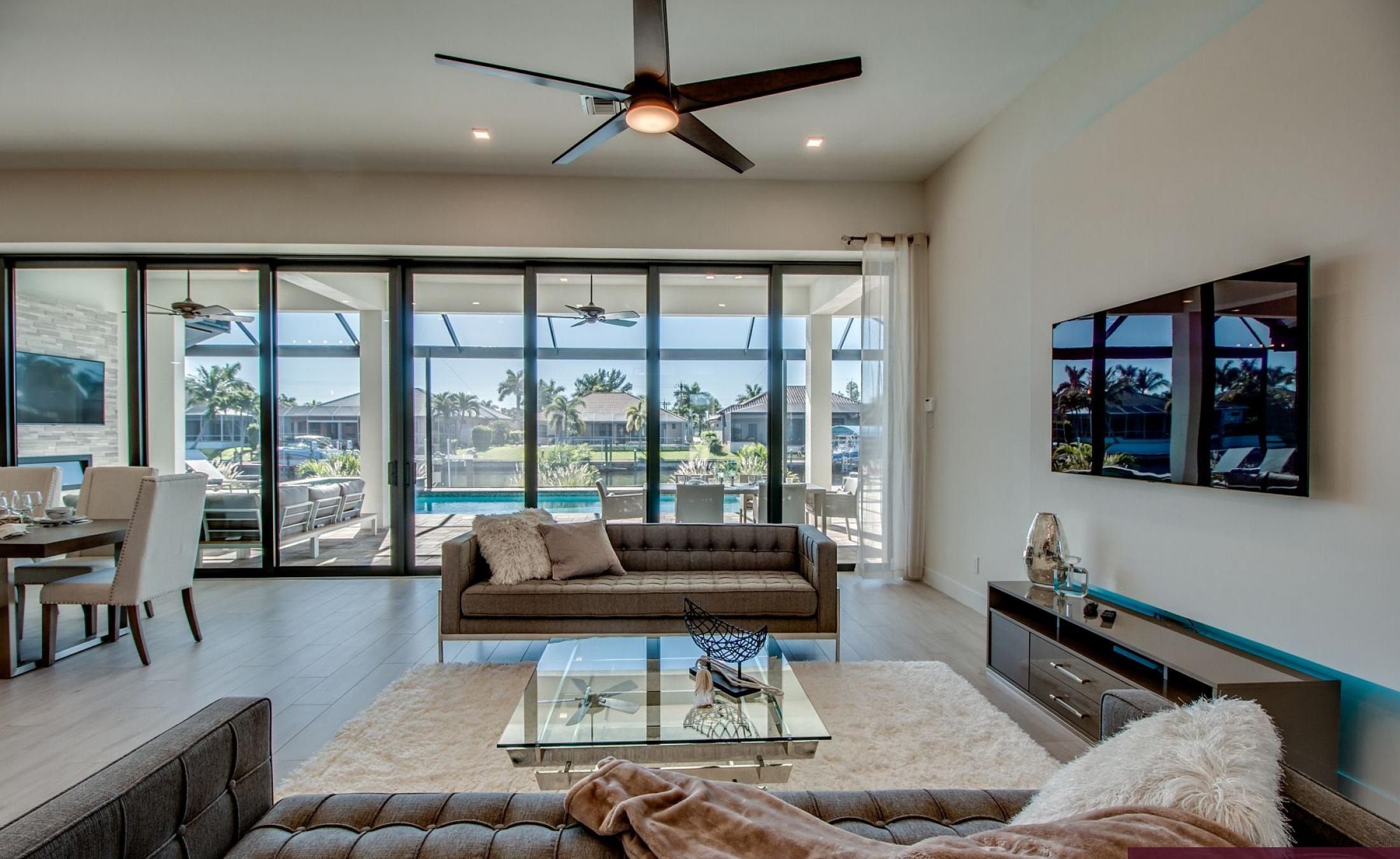 Außenbereich mit Pool, Spa und Grillplatz am Wasser.