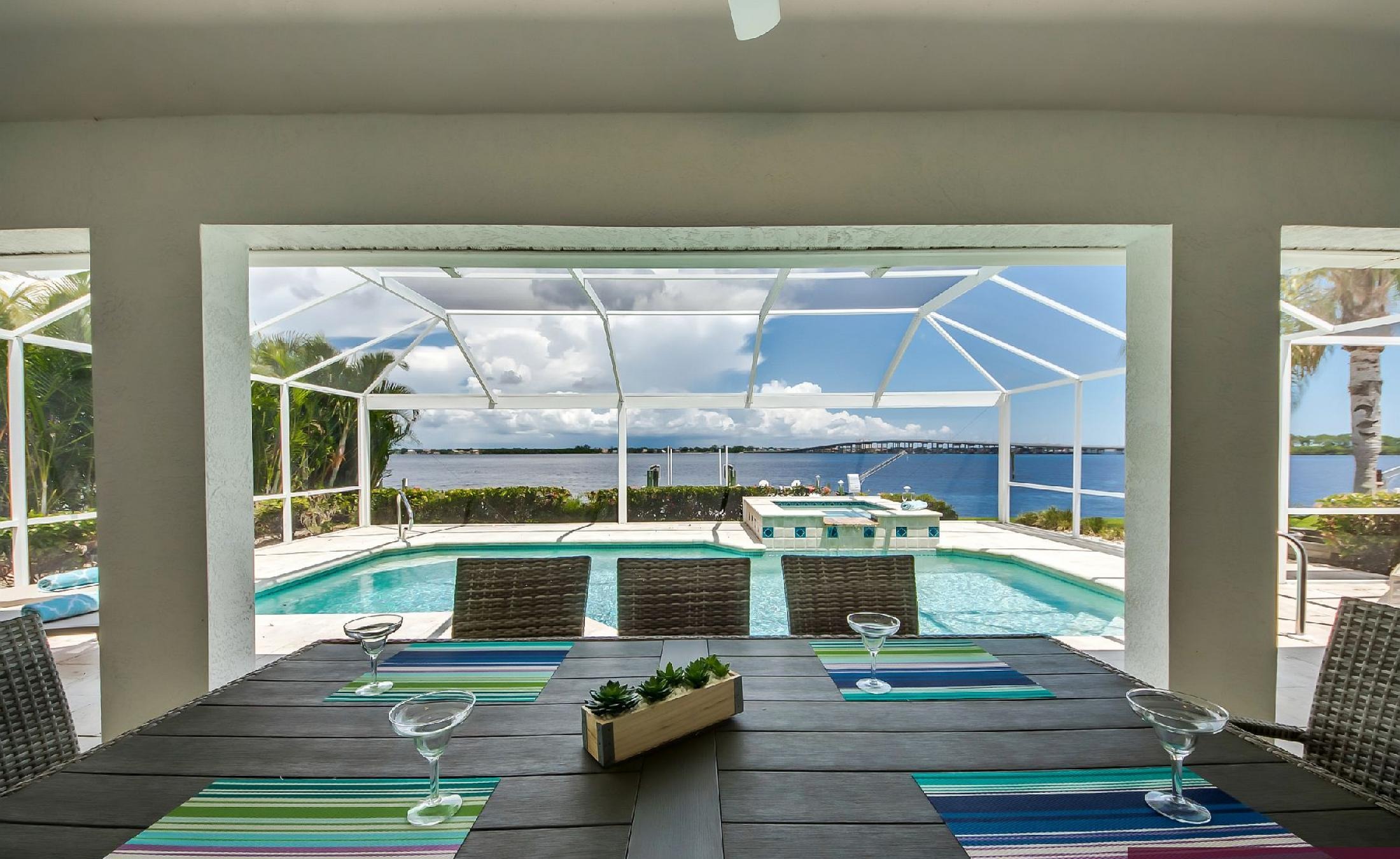 Bootsdock mit Bootslift am Flussufer und weitem Wasserblick.