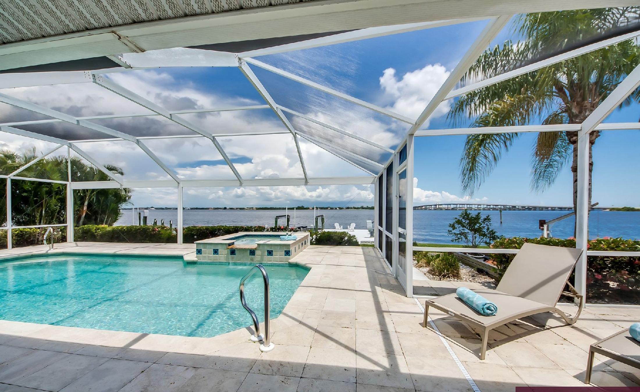 Bootsdock mit Bootslift am Flussufer und weitem Wasserblick.