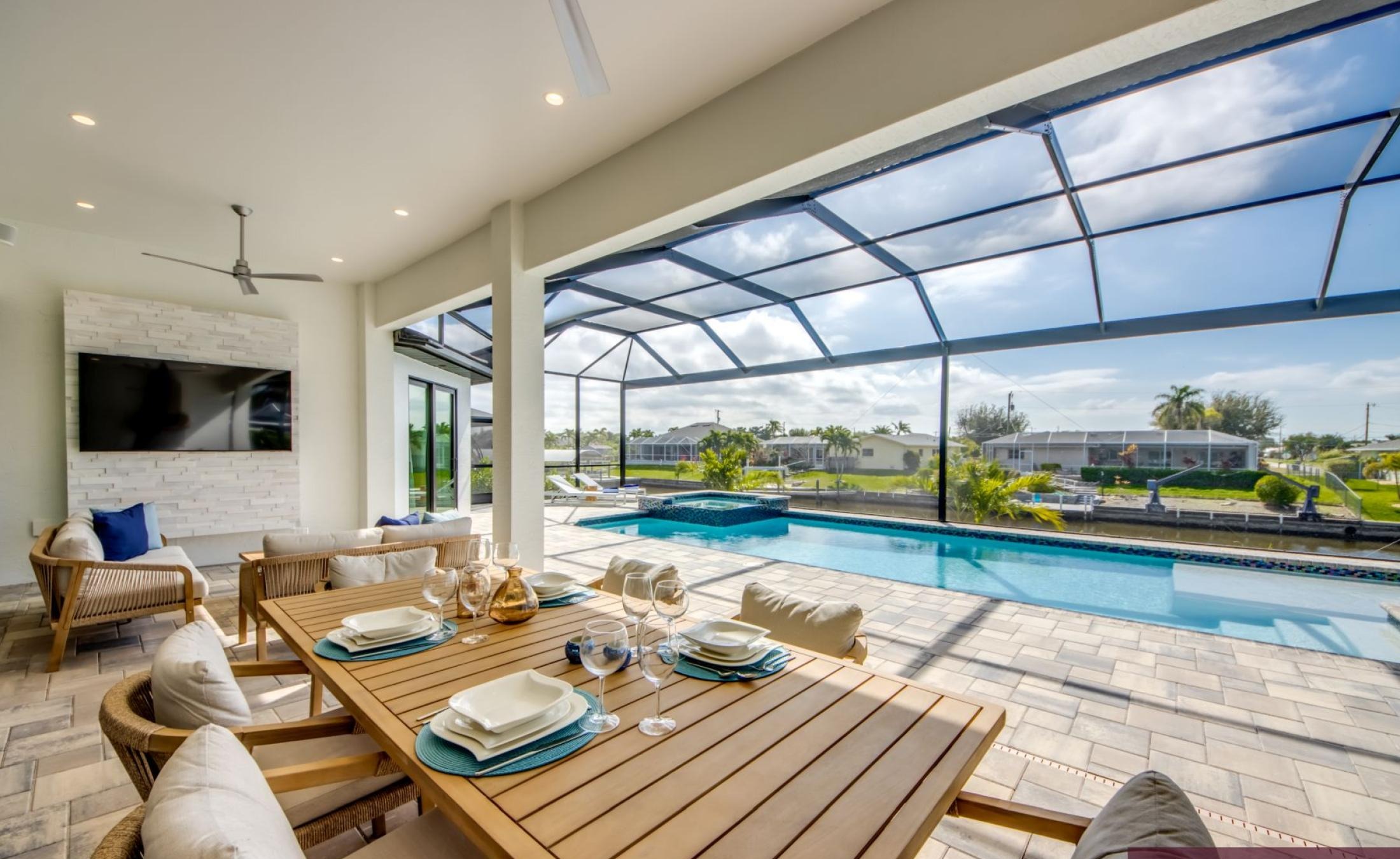 Südseitige Poolterrasse mit beheiztem Pool, Spa und Blick auf den Kanal mit Bootsdock.