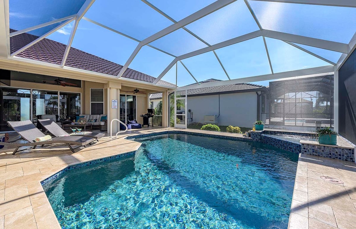 Überdachte Lanai mit Esstisch und Blick auf den Kanal.