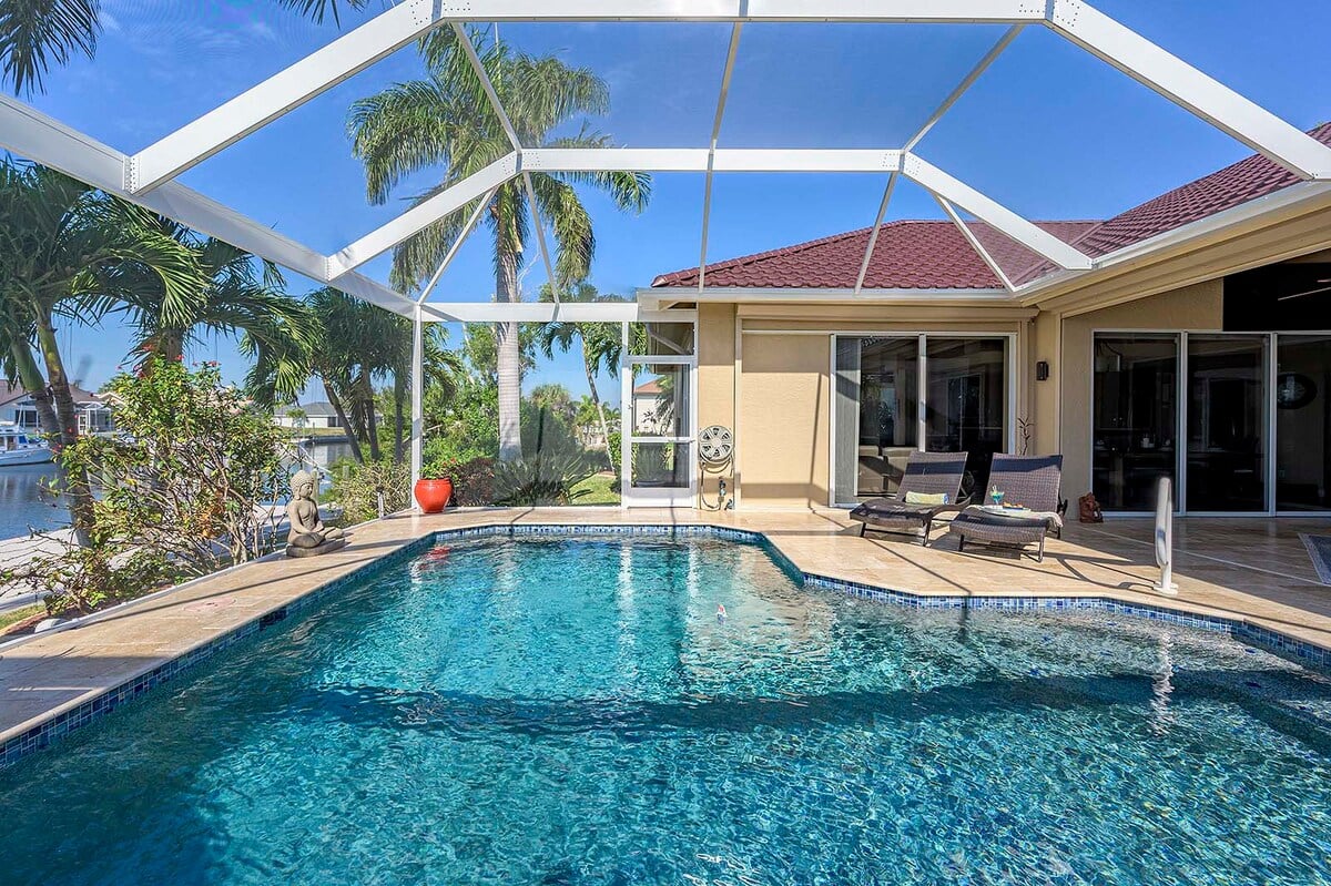 Überdachte Lanai mit Esstisch und Blick auf den Kanal.