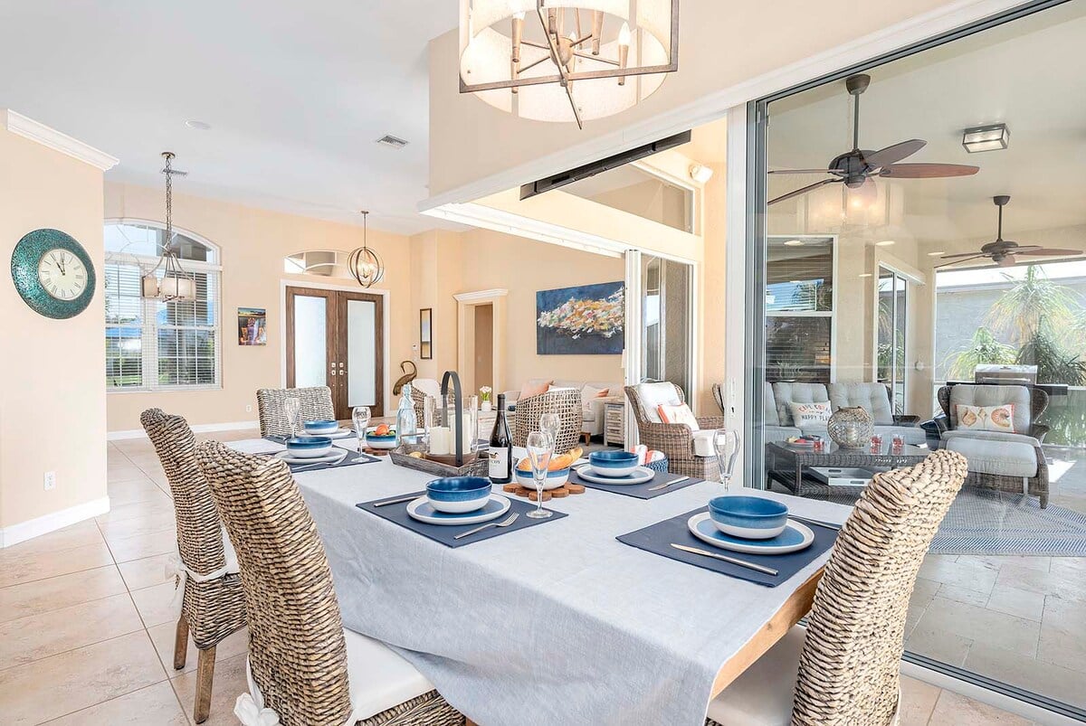 Überdachte Lanai mit Esstisch und Blick auf den Kanal.