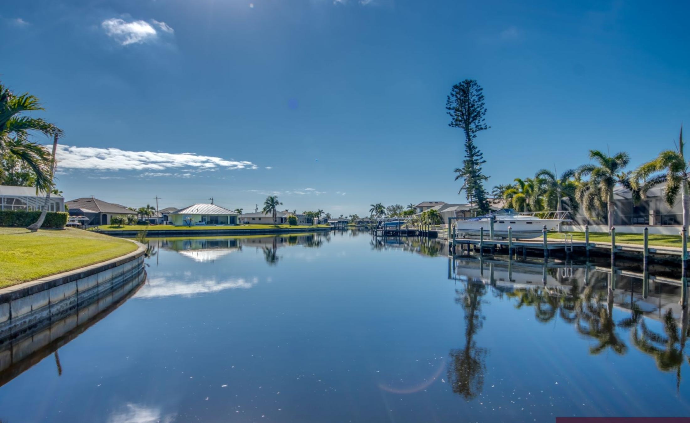 Bootsdock mit Bootslift am Kanal (Gulf Access) bei Sonnenuntergang.