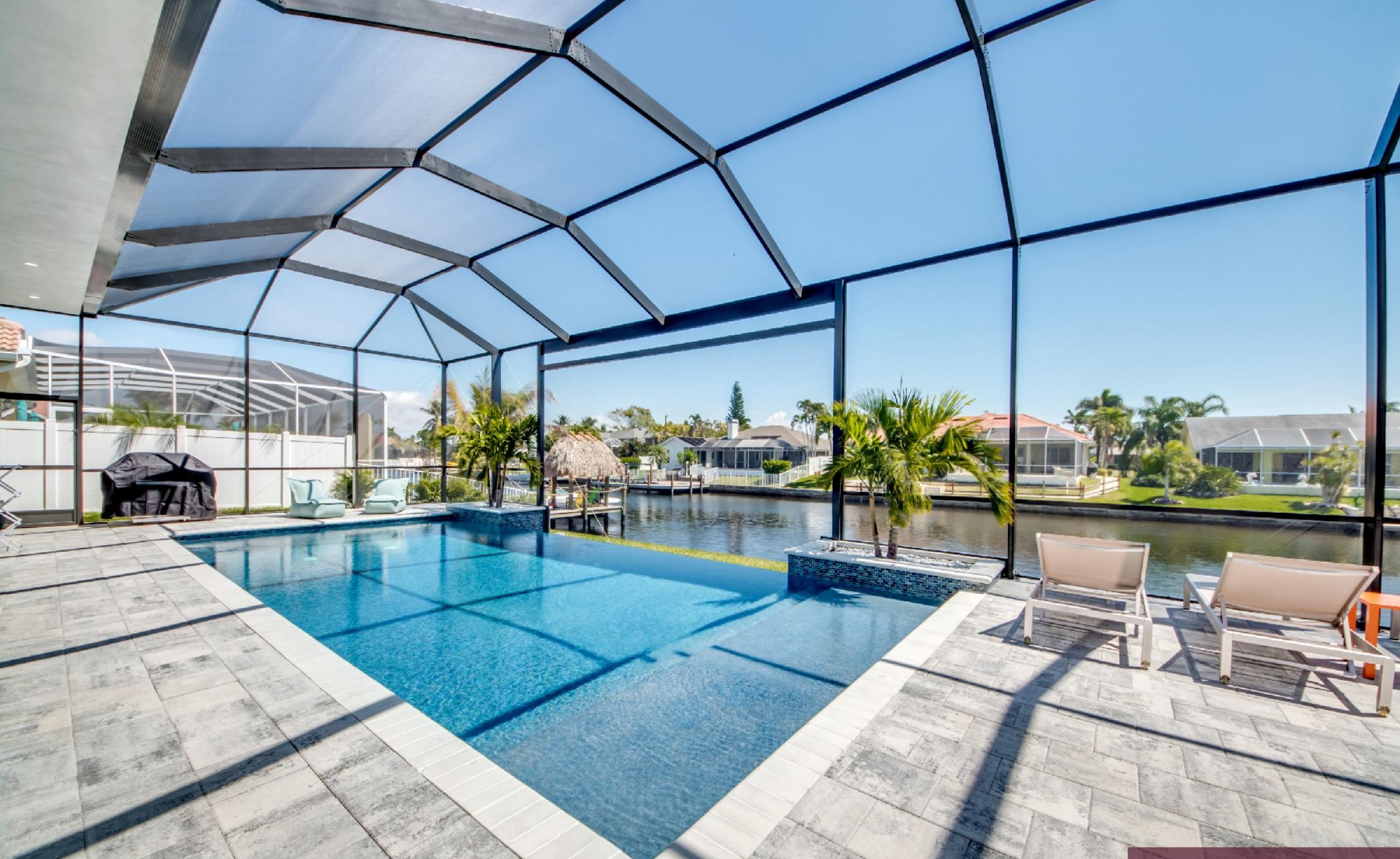 Moderner Salzwasser-Infinity-Pool mit Spa und Blick auf den Kanal.
