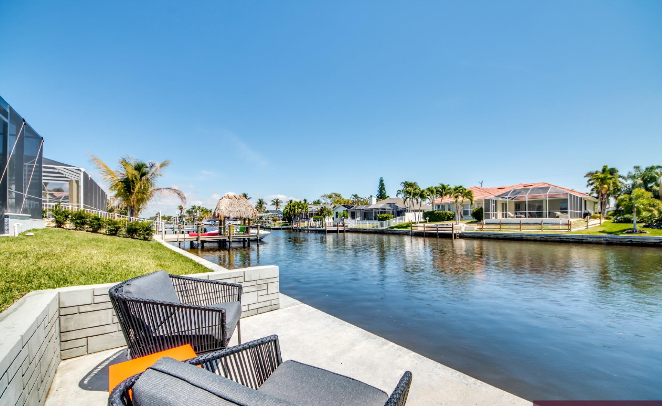 Moderner Poolbereich mit Infinity-Pool und Spa am Kanal mit Bootsdock.