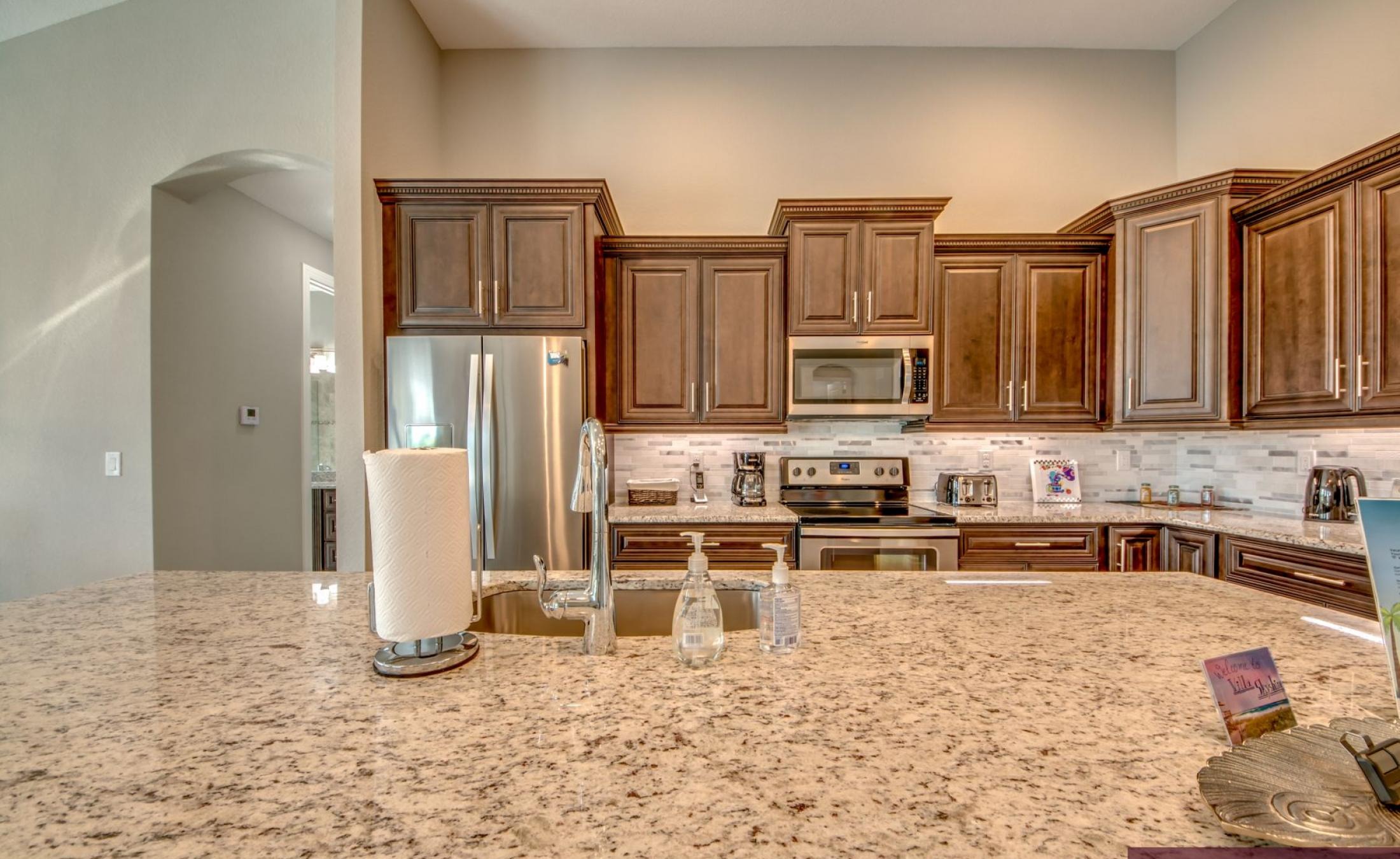 Sonnige Poolterrasse am Kanal mit Bootsdock und Blick aufs Wasser.