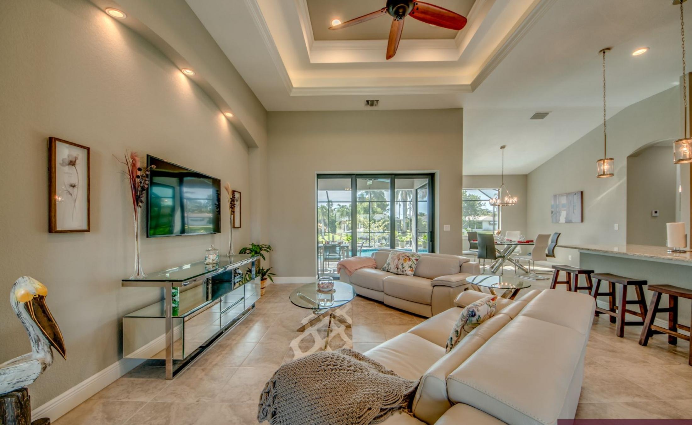 Sonnige Poolterrasse am Kanal mit Bootsdock und Blick aufs Wasser.