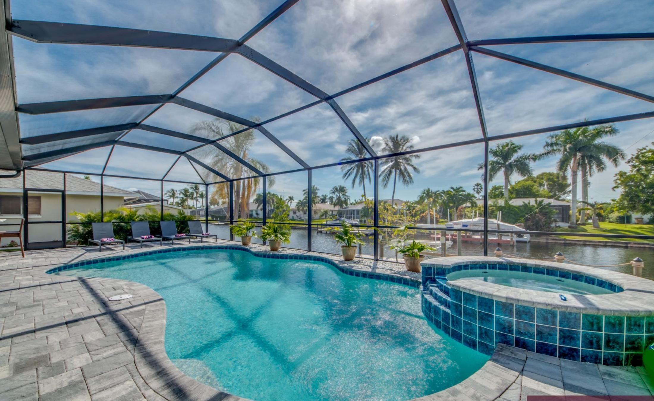 Sonnige Poolterrasse mit beheiztem Pool und Spa am Kanal mit Bootsdock.