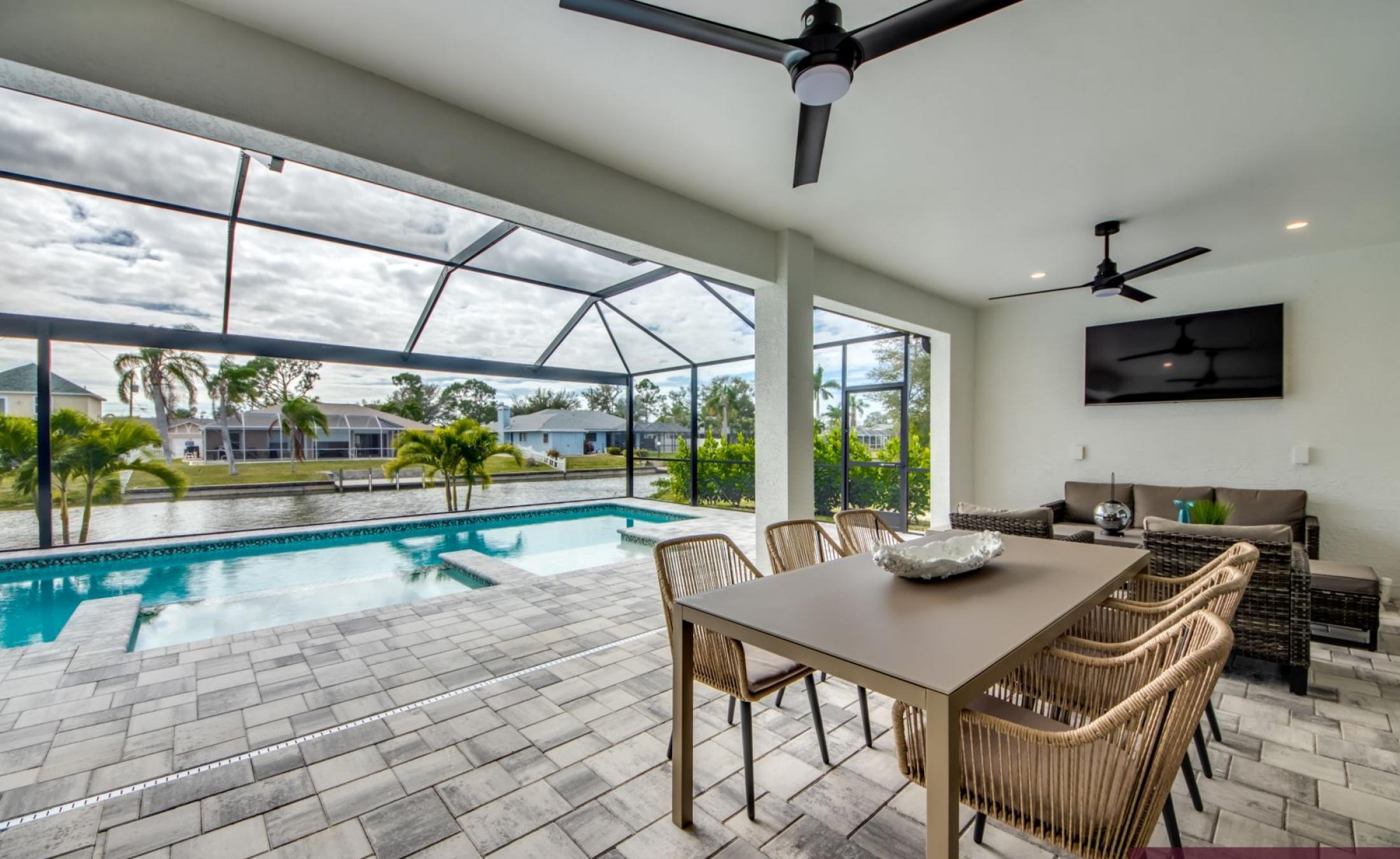 Sonniger Poolbereich mit Spa und Blick auf den Frischwasserkanal.