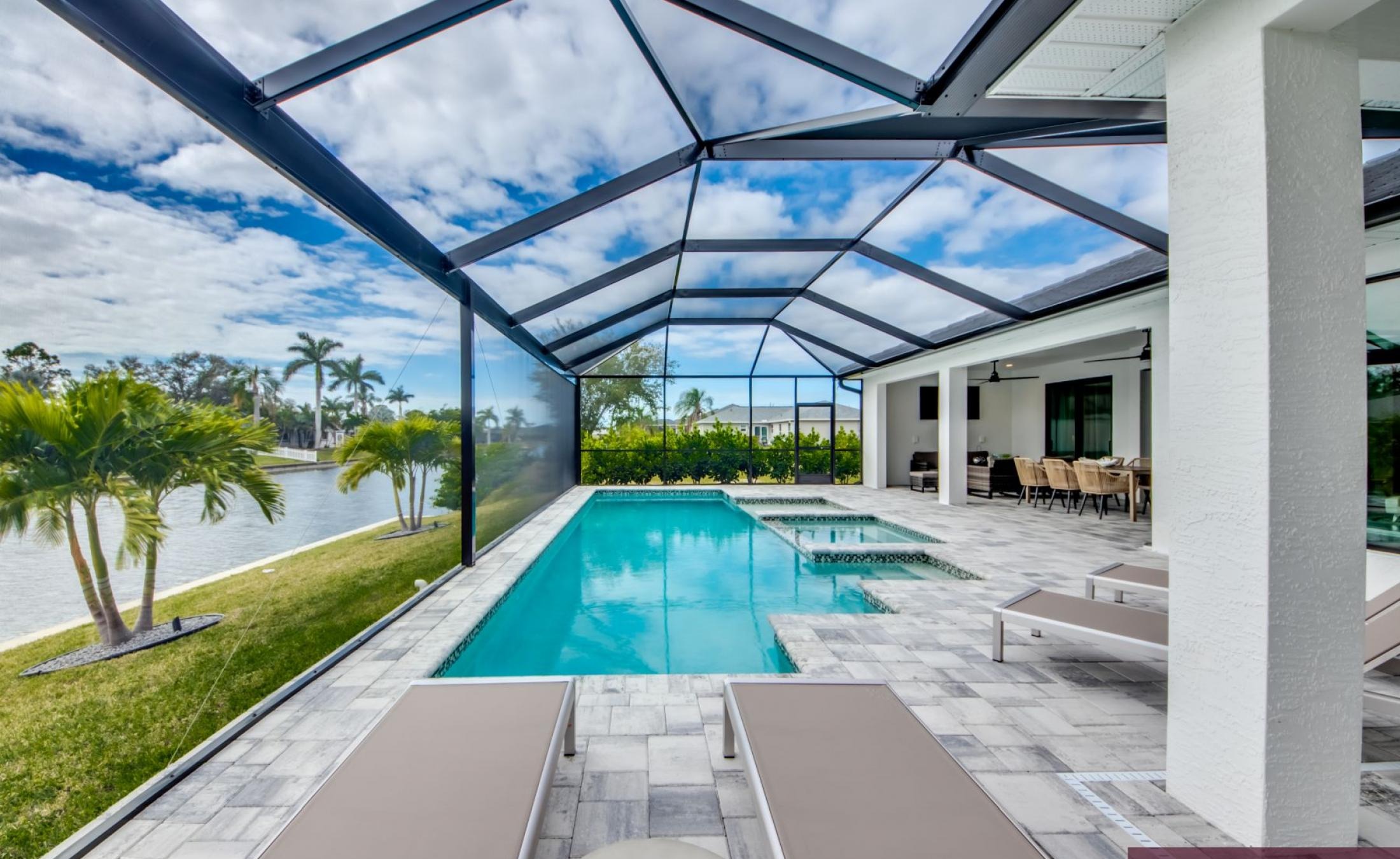 Sonnenüberfluteter Poolbereich mit beheiztem Pool und Spa an einem Frischwasserkanal.